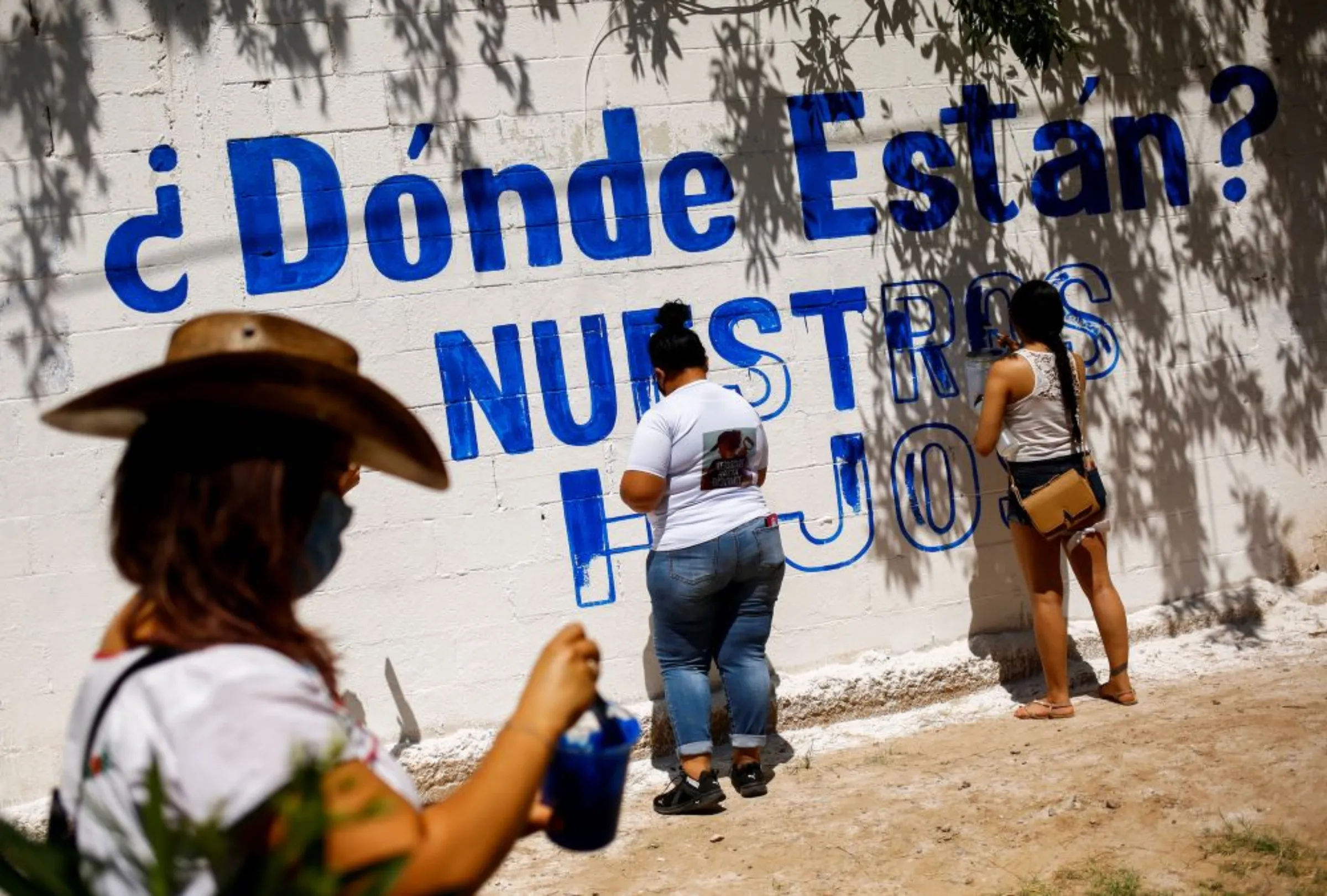 Relatives of missing persons and activists paint a mural that reads: 'Where are they? Our children', during a memorial to mark the International Day of the Victims of Enforced Disappearances in Ciudad Juarez, Mexico August 29, 2021