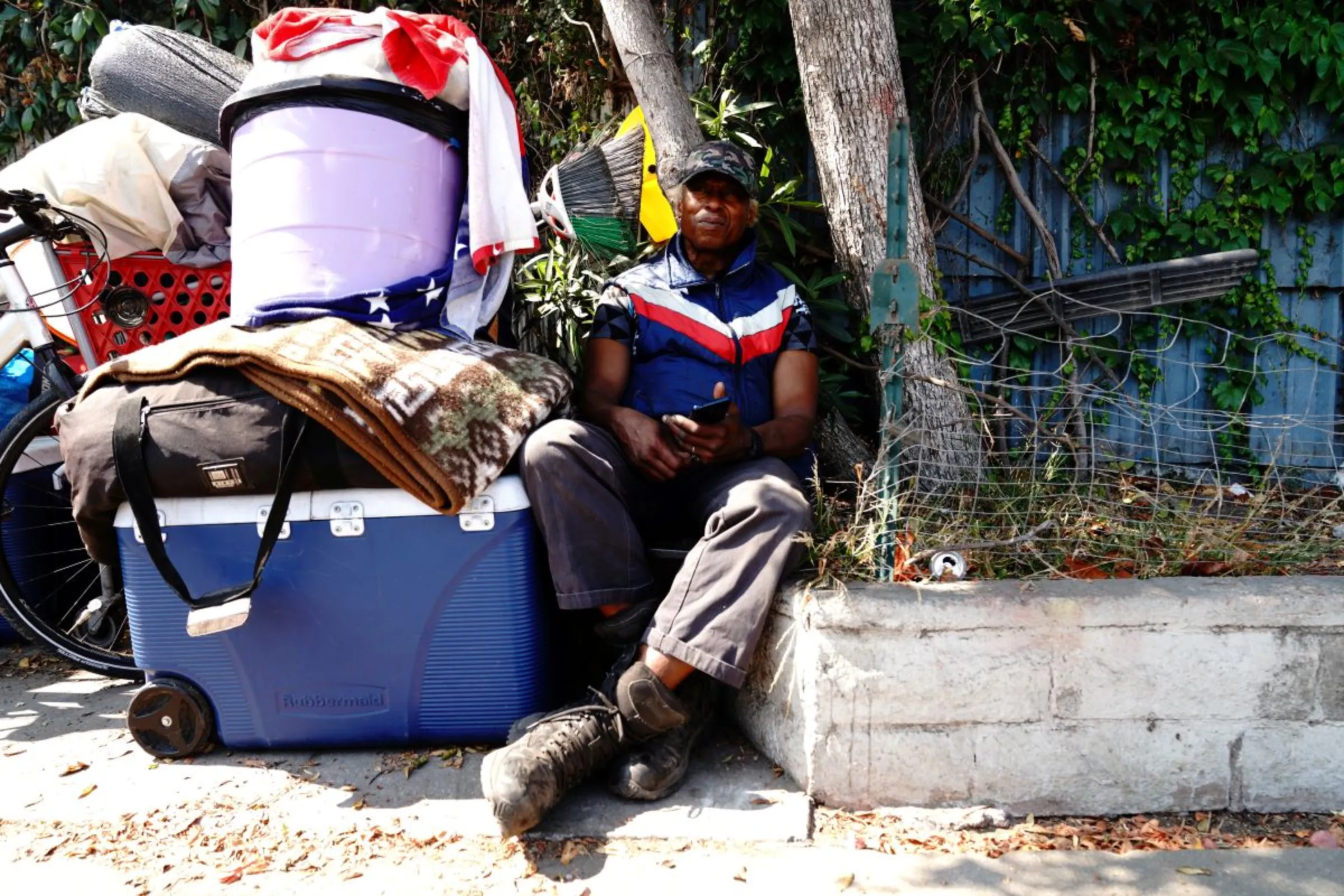 An unhoused person poses for a portrait after being displaced by police and sanitation workers clearing unhoused people from a homeless encampment in Harbor City, Los Angeles, California, U.S., July 1, 2021. REUTERS/Bing Guan