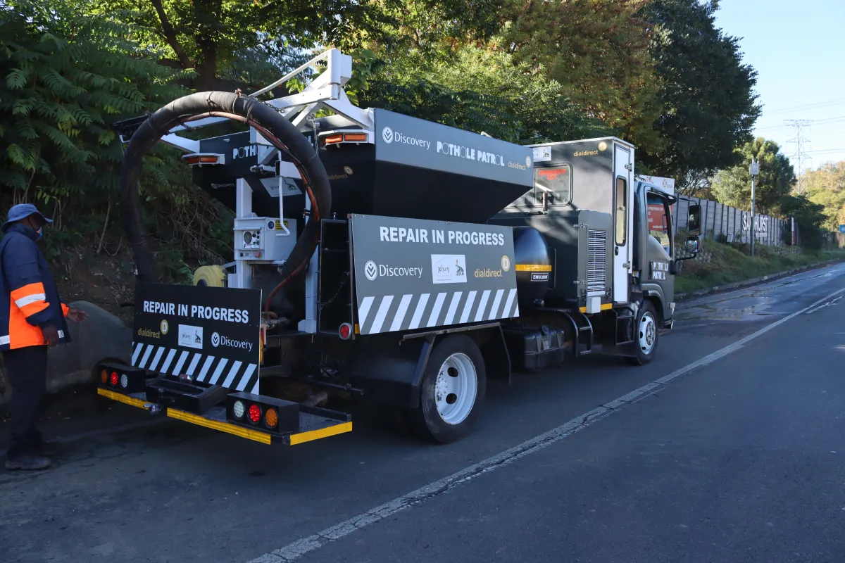 The Pothole Patrol truck pauses on a road to repair a pothole