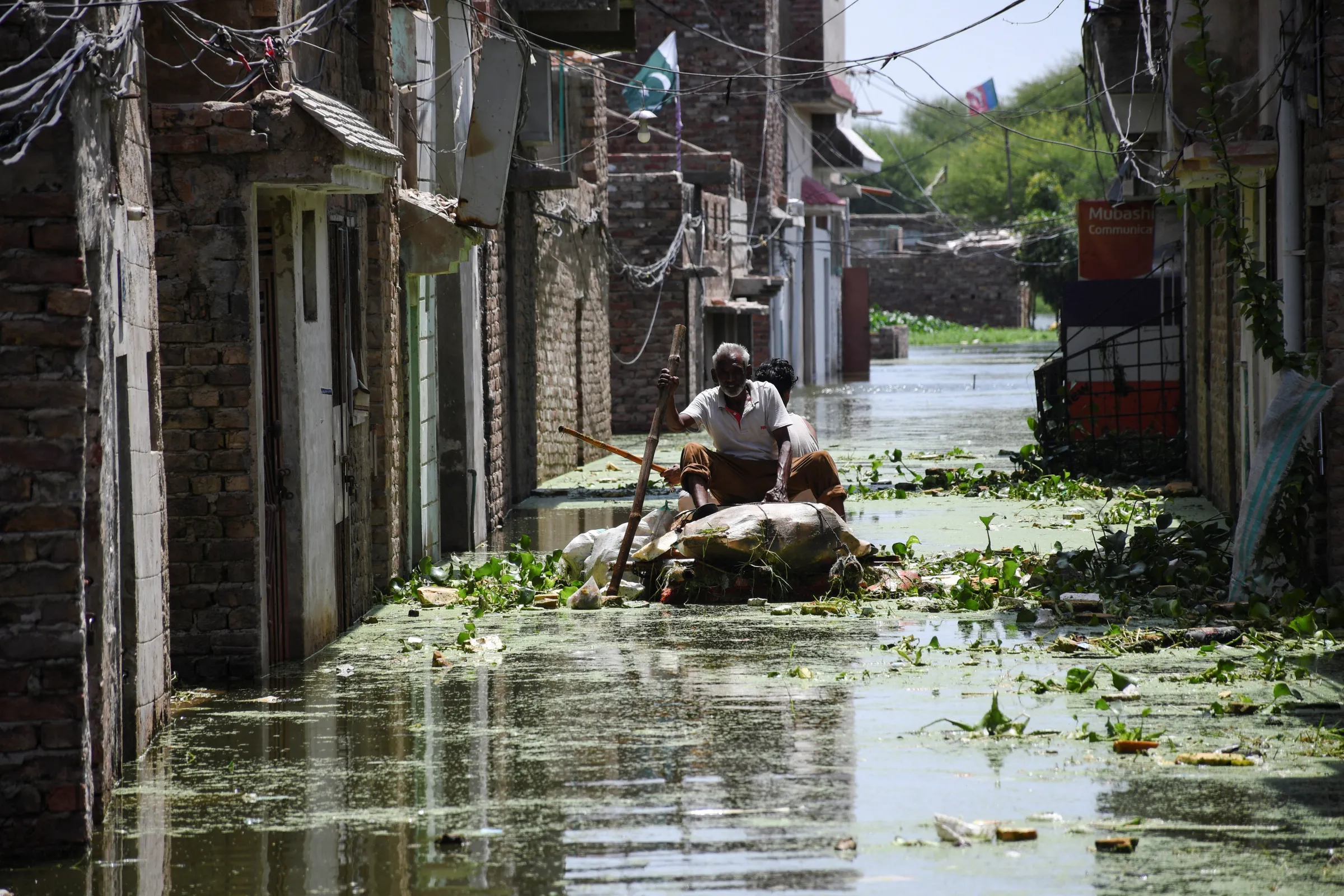 Men use a makeshift raft as they cross a flooded street in a residential area, following rains during the monsoon season in Hyderabad, Pakistan September 5, 2022. REUTERS/Yasir Rajput