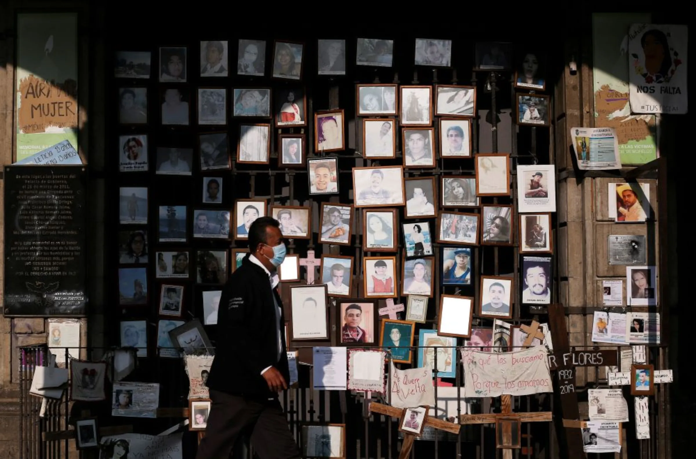 A man walks past framed photos of missing persons placed outside the Morelos government palace, in Cuernavaca, in Morelos state, Mexico September 15, 2022
