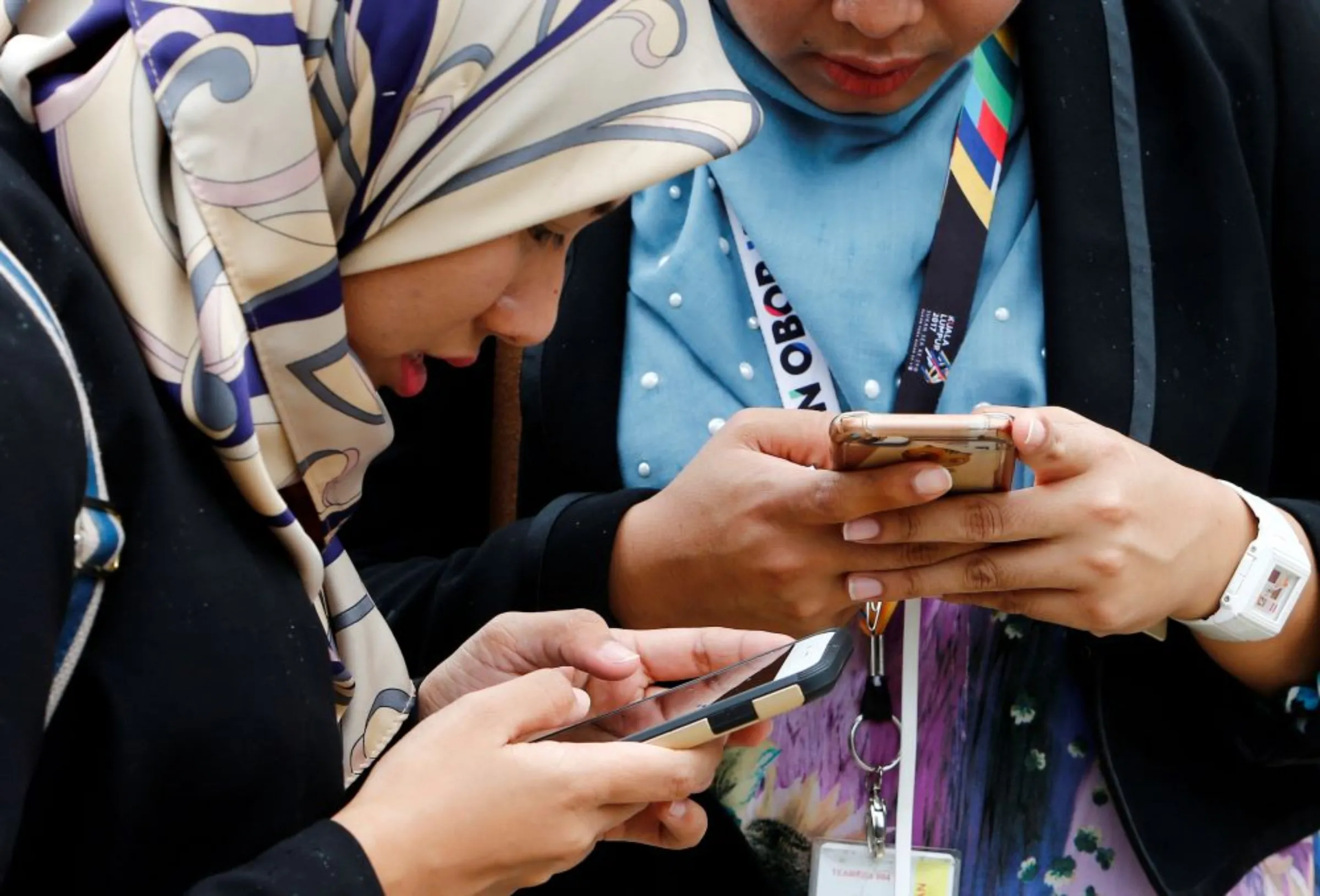 Women use their mobile phones at a university in Semenyih, outside Kuala Lumpur, Malaysia November 3, 2017