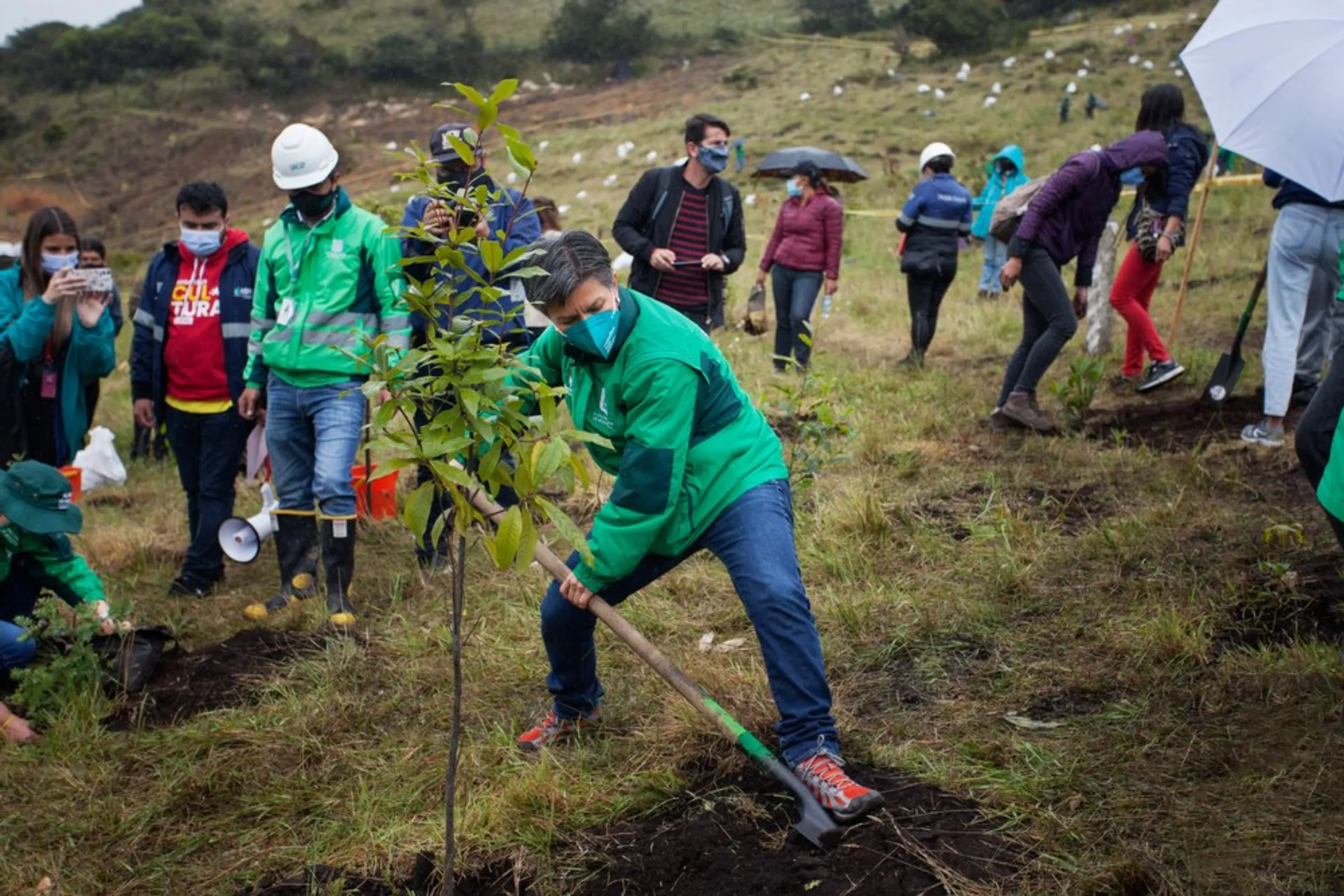 Claudia Lopez, the mayor of Colombia’s capital of Bogota, helps dig in one of more than 53,000 trees planted in and around the capital since 2020, on April 29, 2021