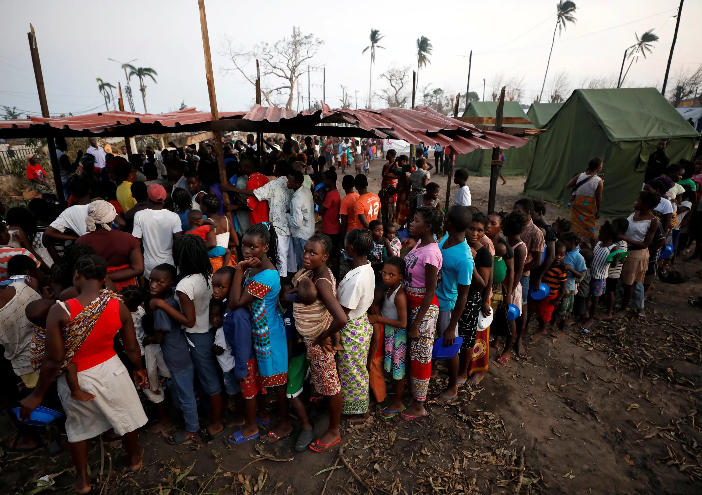 People queue for food in a camp for people displaced in the aftermath of Cyclone Idai in Beira, Mozambique, March 26, 2019