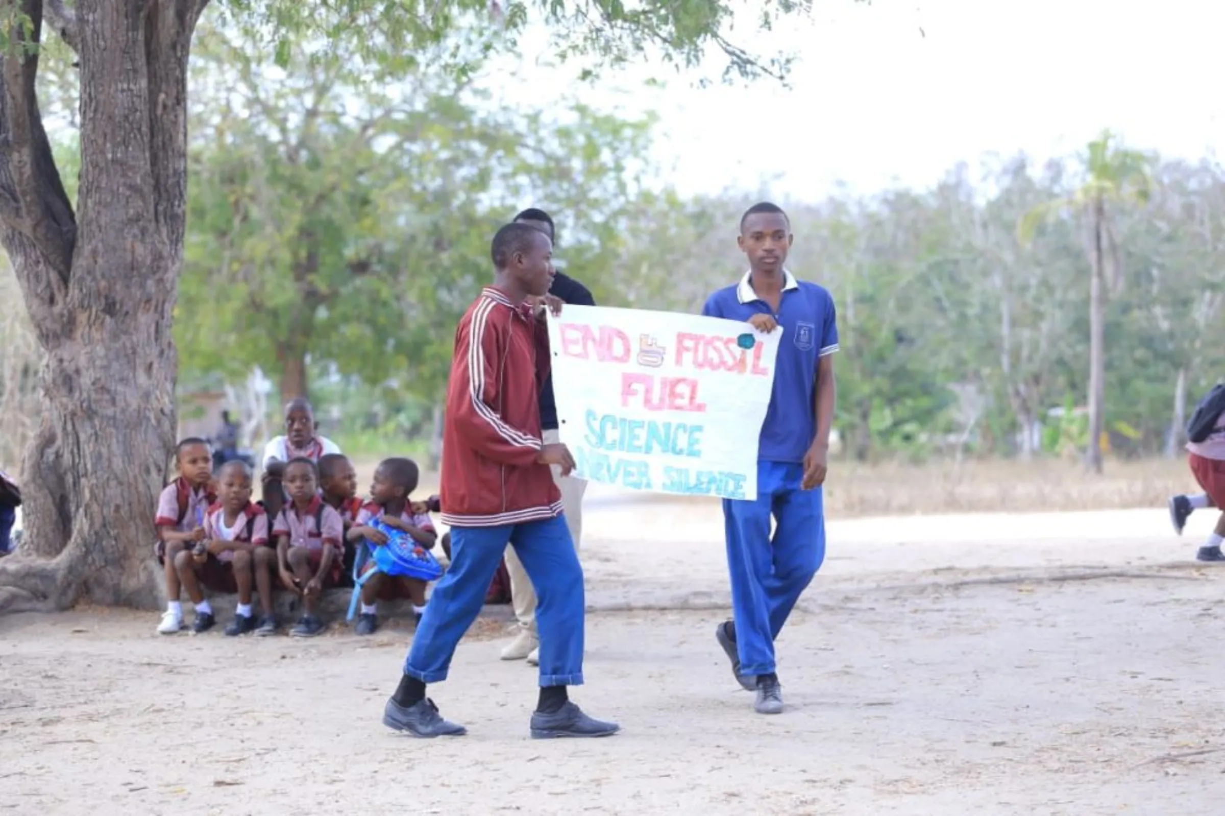 Two students hold a sign reading ‘End of Fossil Fuel, Science Never Silence’ at a climate strike in the Kibaha district, Tanzania, October 9, 2022
