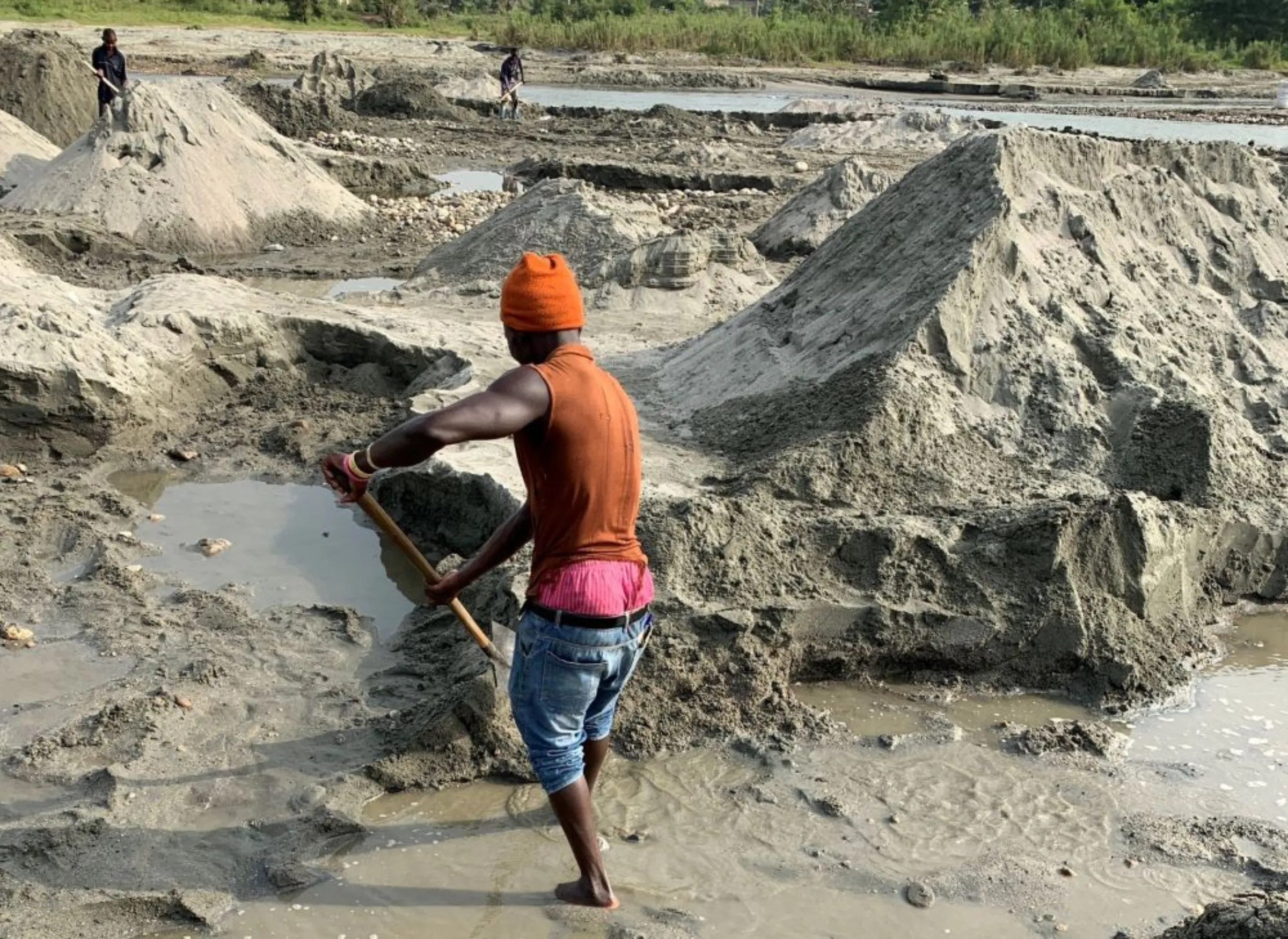 A man mines sand along the river in Uganda