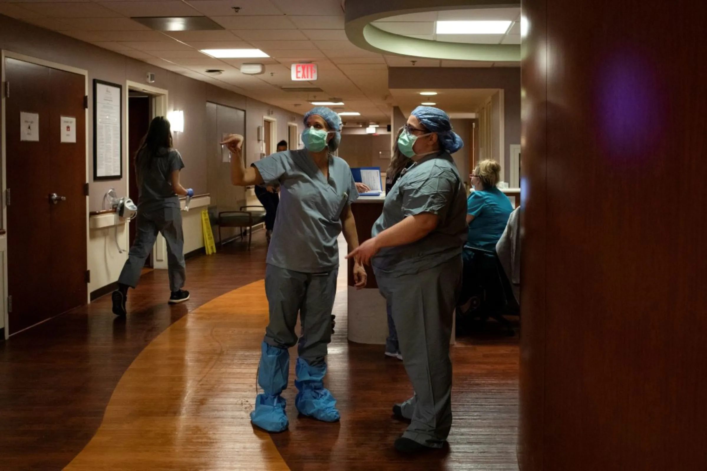 A doctor and nurse consult in the hallway as a patient prepares to be transferred for an emergency C-section in the Family Birth Center at Beaumont Hospital in Royal Oak, Michigan, U.S., February 1, 2022