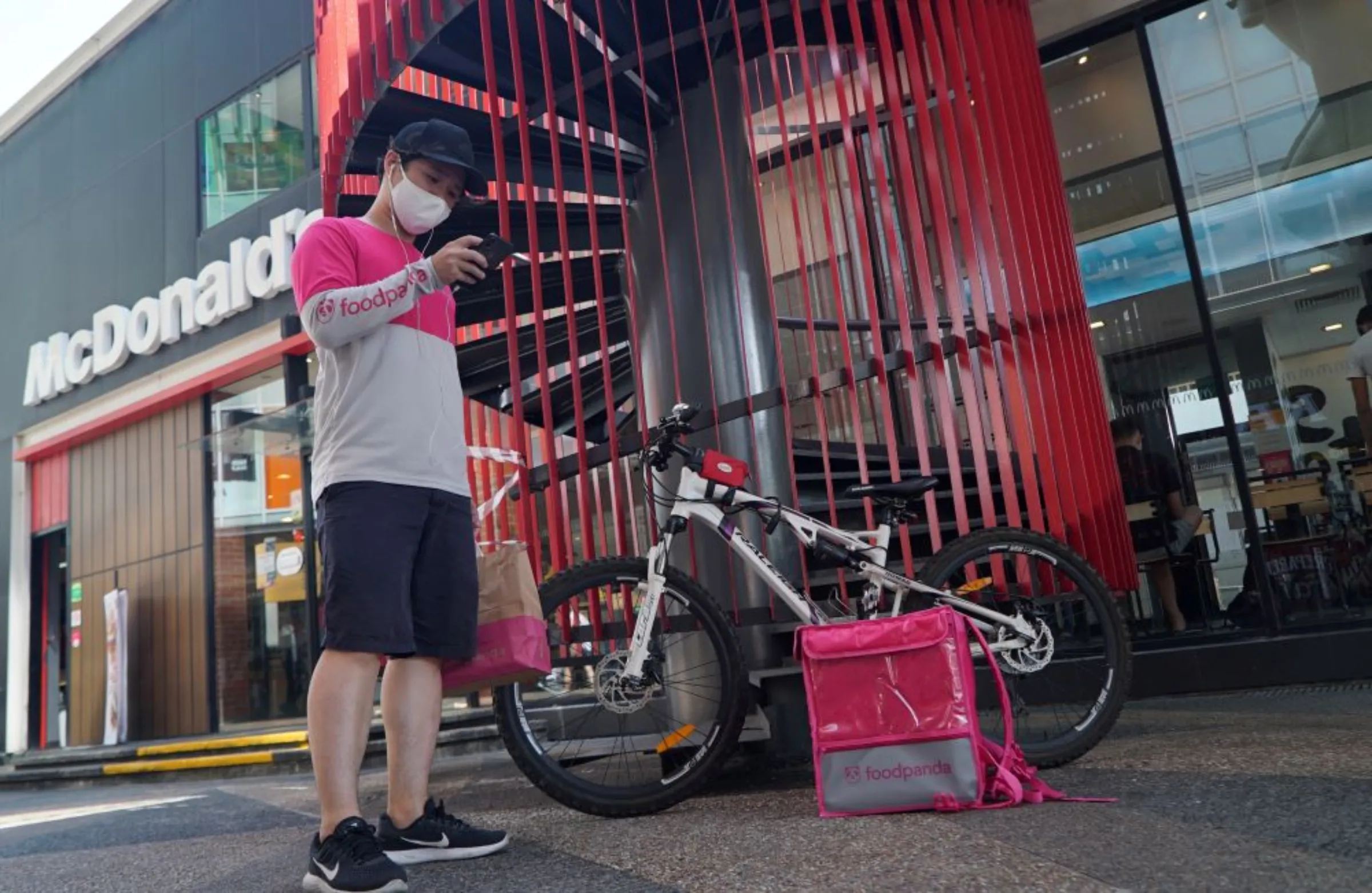 A food delivery driver checks his phone before making a food delivery, amid the coronavirus disease (COVID-19) outbreak, in Singapore March 9, 2021. REUTERS/Joseph Campbell