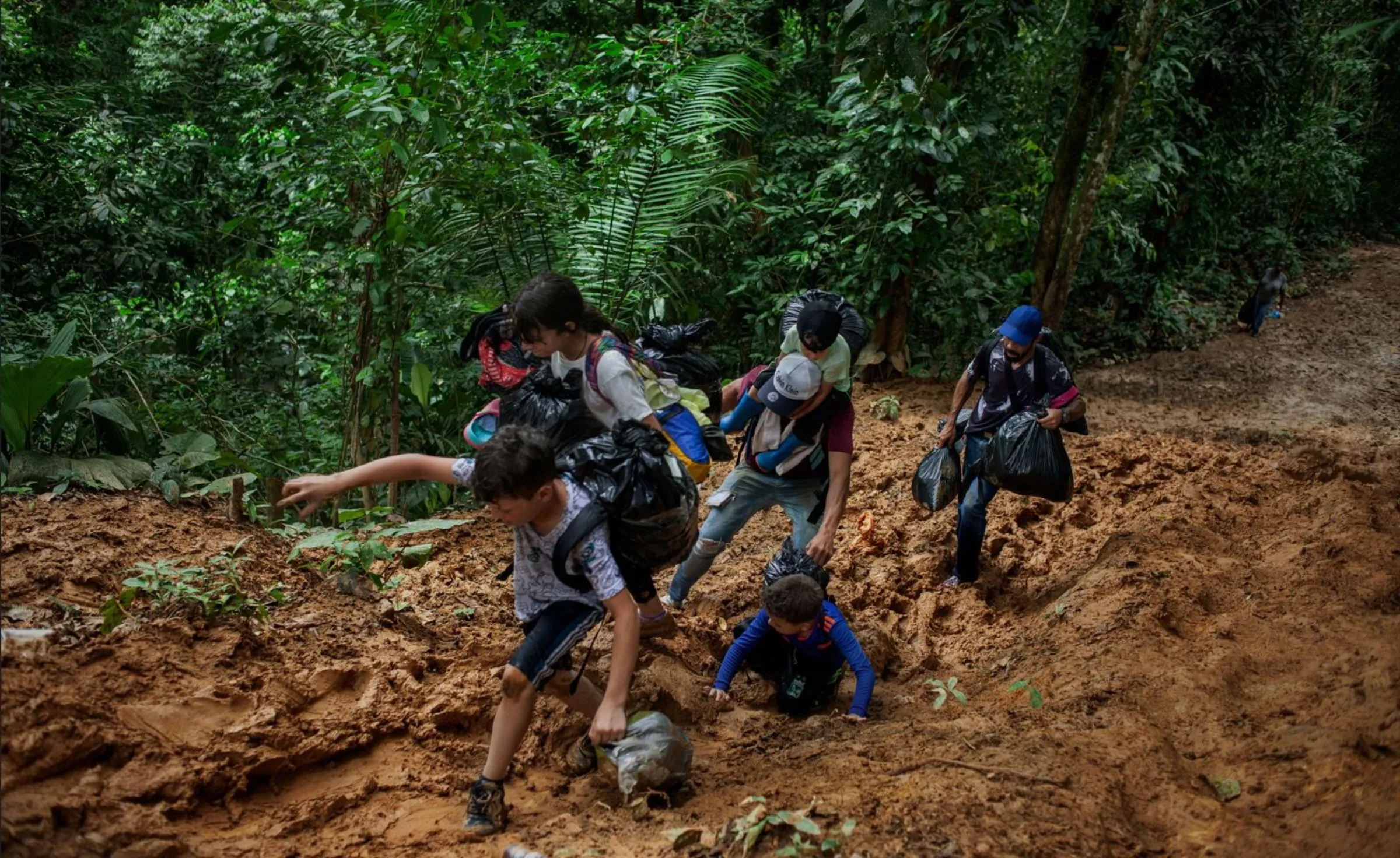 A family of Venezuelan migrants with young children walk through the Colombian jungle in the Darien Gap on day one of a five- to seven-day perilous and exhausting trek. Darién Gap, July 27, 2022. Thomson Reuters Foundation/Fabio Cuttica