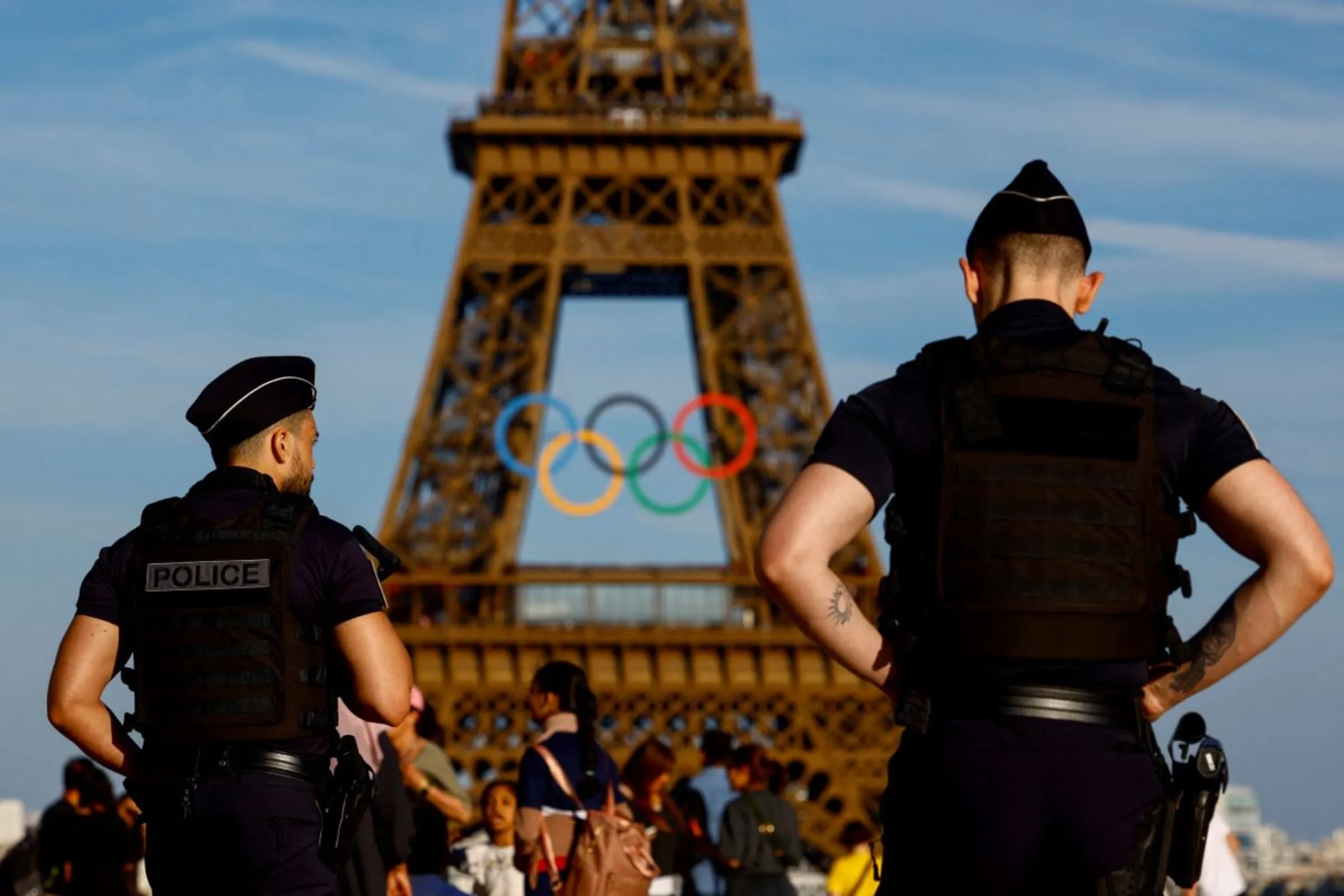 Police officers patrol in front of the Olympic rings displayed on the Eiffel Tower ahead of the Paris 2024 Olympic games in Paris, France, June 7, 2024. REUTERS/Sarah Meyssonnier