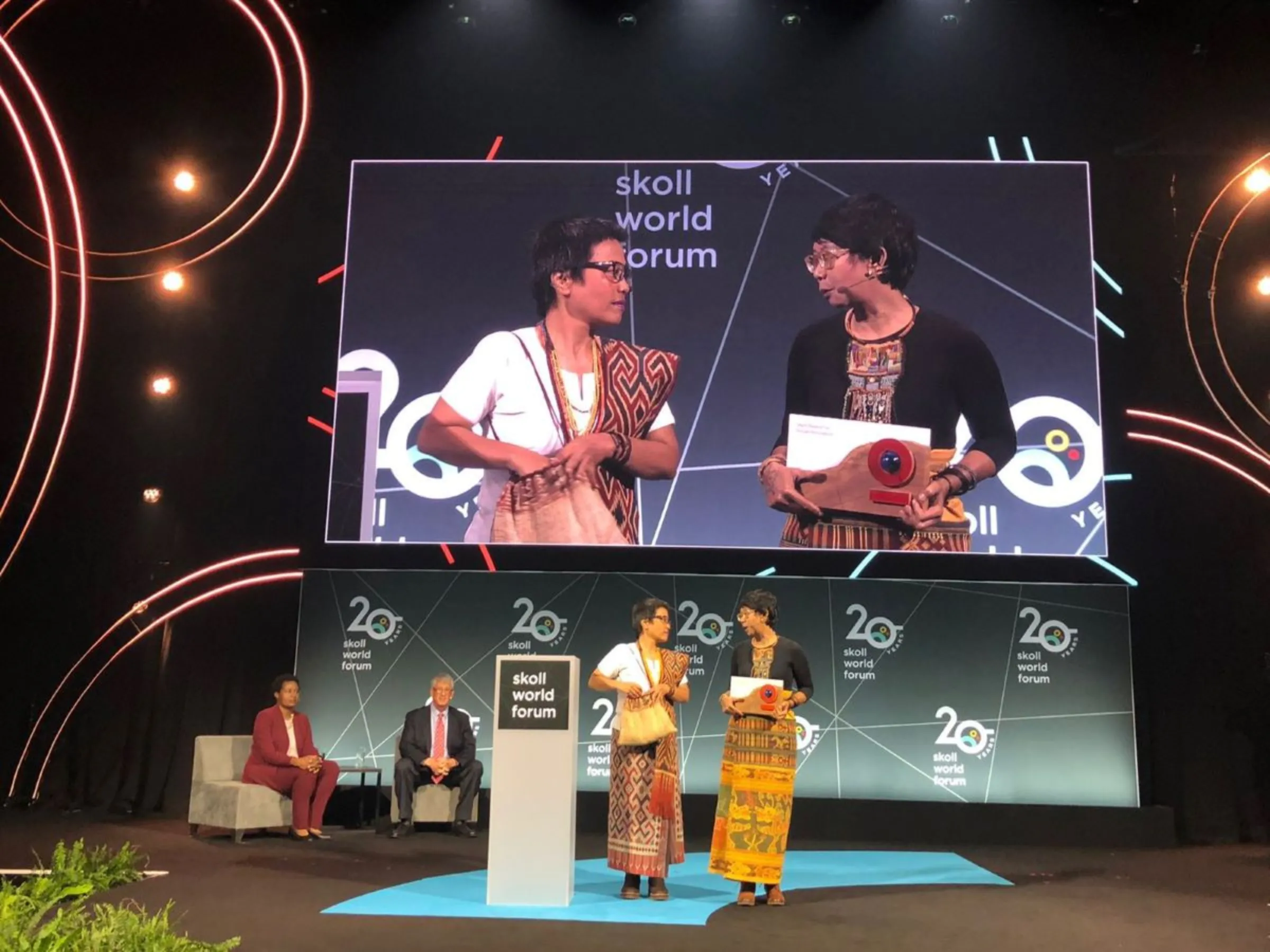 Rukka Sombolinggi and Mina Setra, general secretary and deputy general secretary of AMAN, an alliance that represents 15 million Indigenous people in Indonesia, receive an award for social innovation at the Skoll World Forum in Oxford, England, April 13, 2023