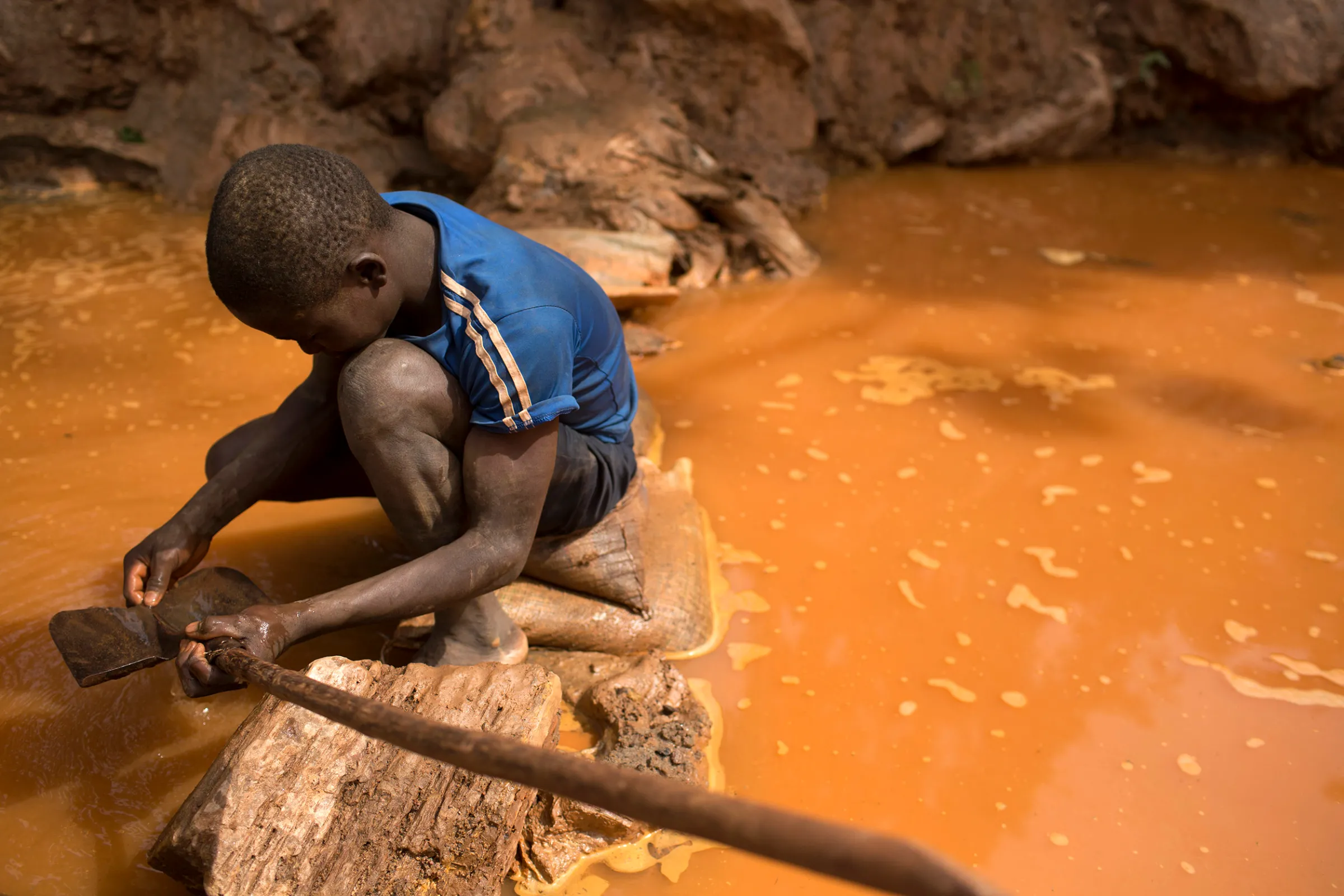 A boy cleans a shovel before panning for gold at the gold mine near Djoubissi, Central African Republic, May 9, 2014. REUTERS/Siegfried Modola