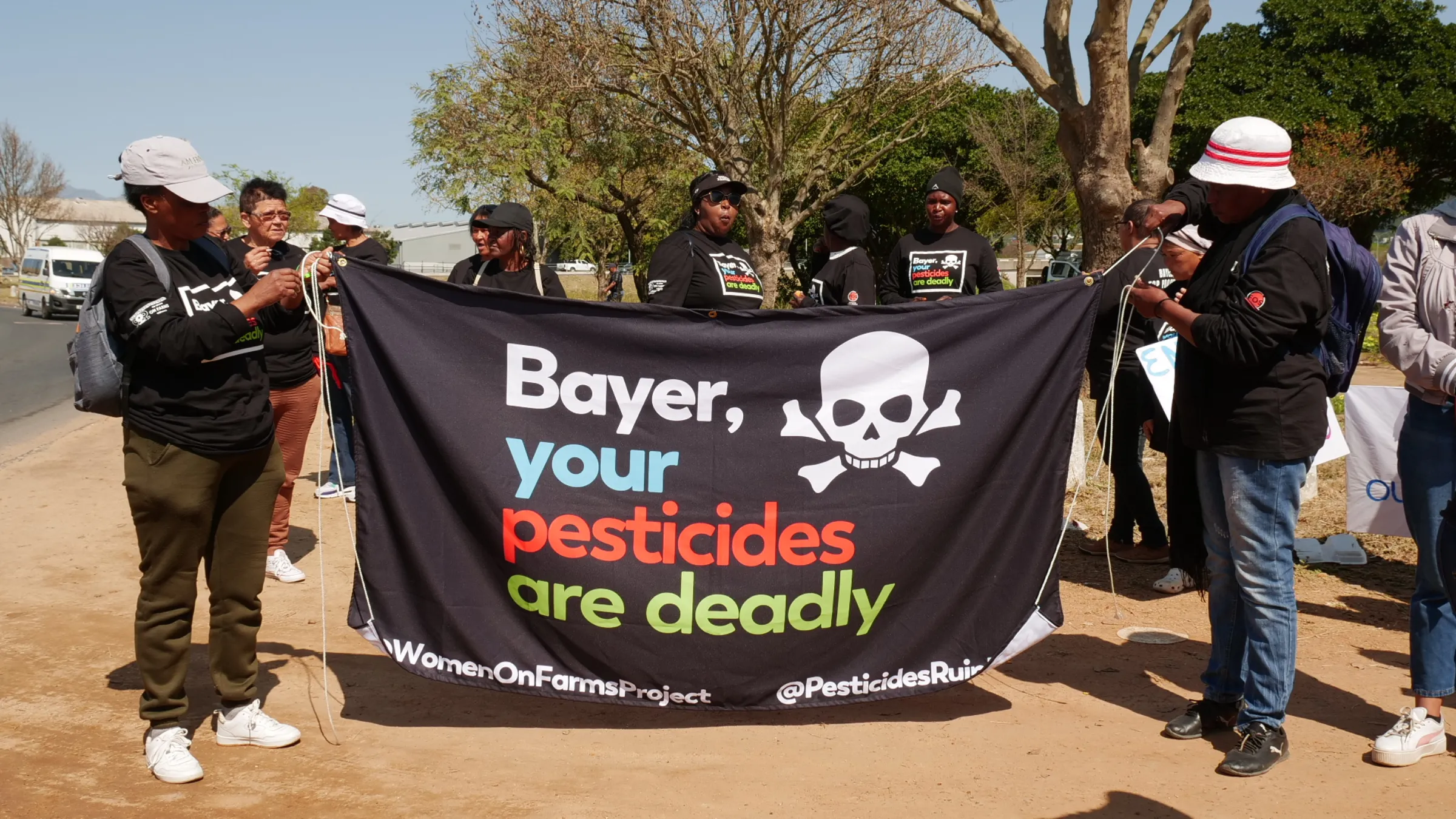 A banner reading ‘Bayer, your pesticides are deadly’ alongside a skull and crossbones is displayed at a protest march in Paarl, South Africa, September 8, 2023. Thomson Reuters Foundation/Kim Harrisberg