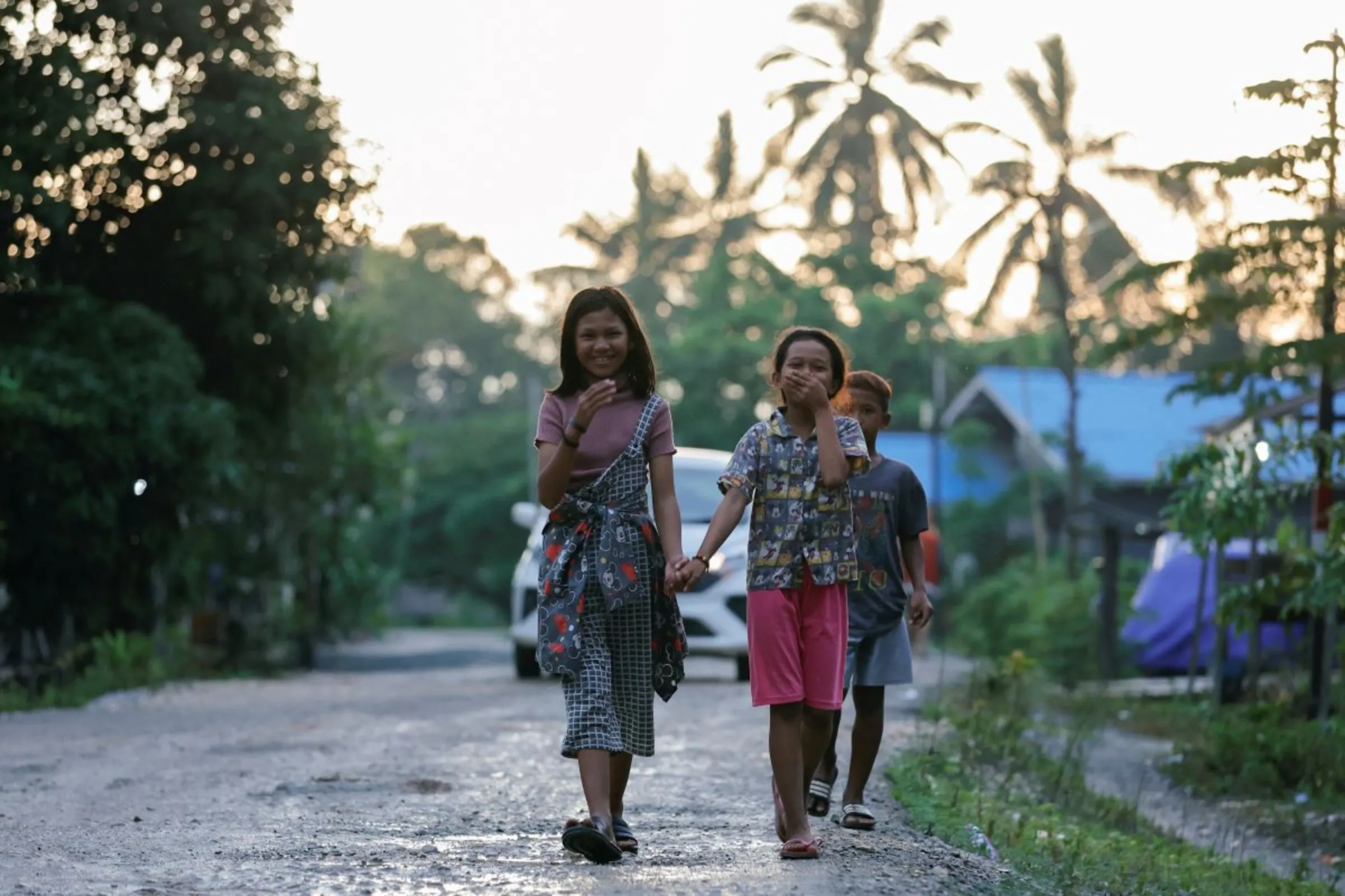 Indigenous Balik tribe's children react to camera as they walk along a road at their village, located near the Indonesia's projected new capital known as Nusantara National Capital, in Sepaku, East Kalimantan province, Indonesia, March 6, 2023