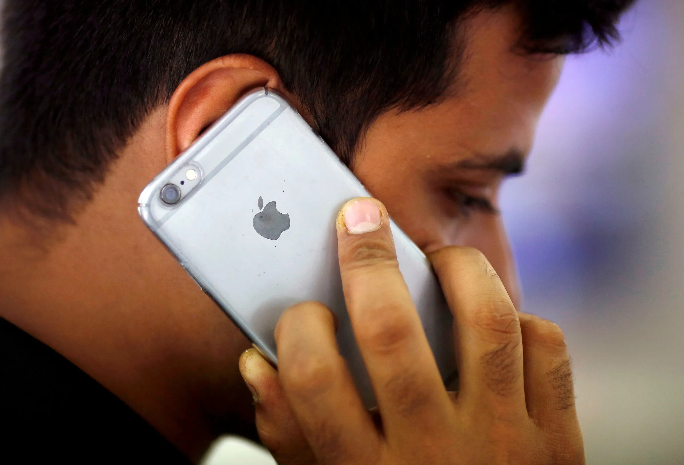 A man talks on his iPhone at a mobile phone store in New Delhi, India, July 27, 2016. REUTERS/Adnan Abid