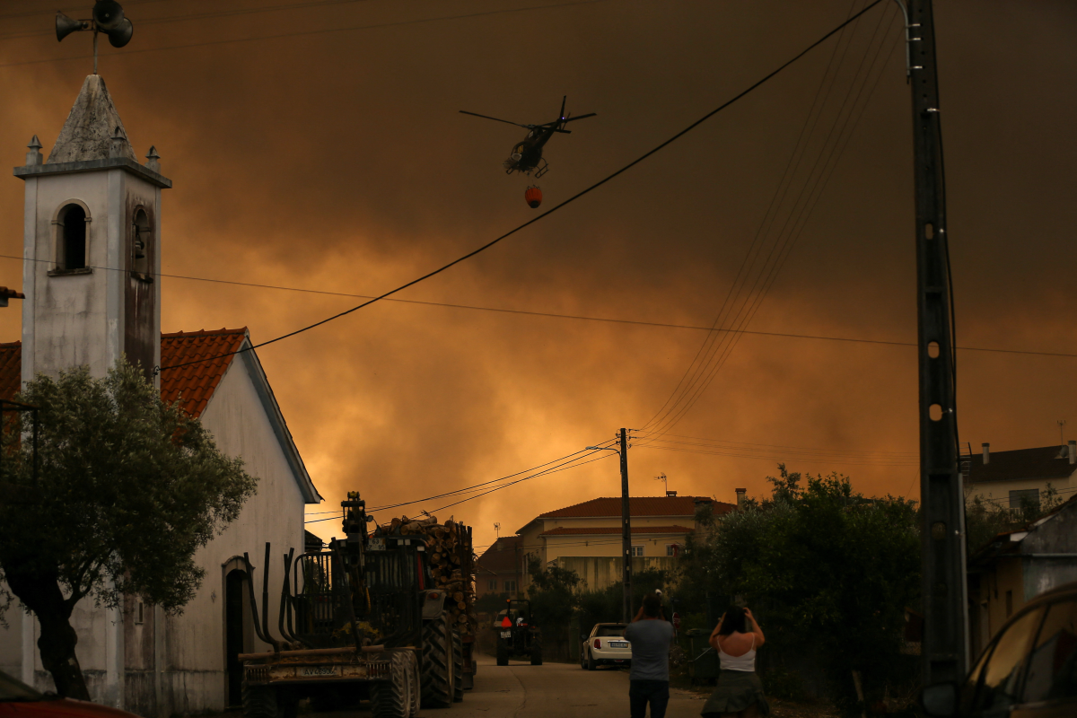 A fire fighting helicopter works to contain a wildfire in Leiria, Portugal