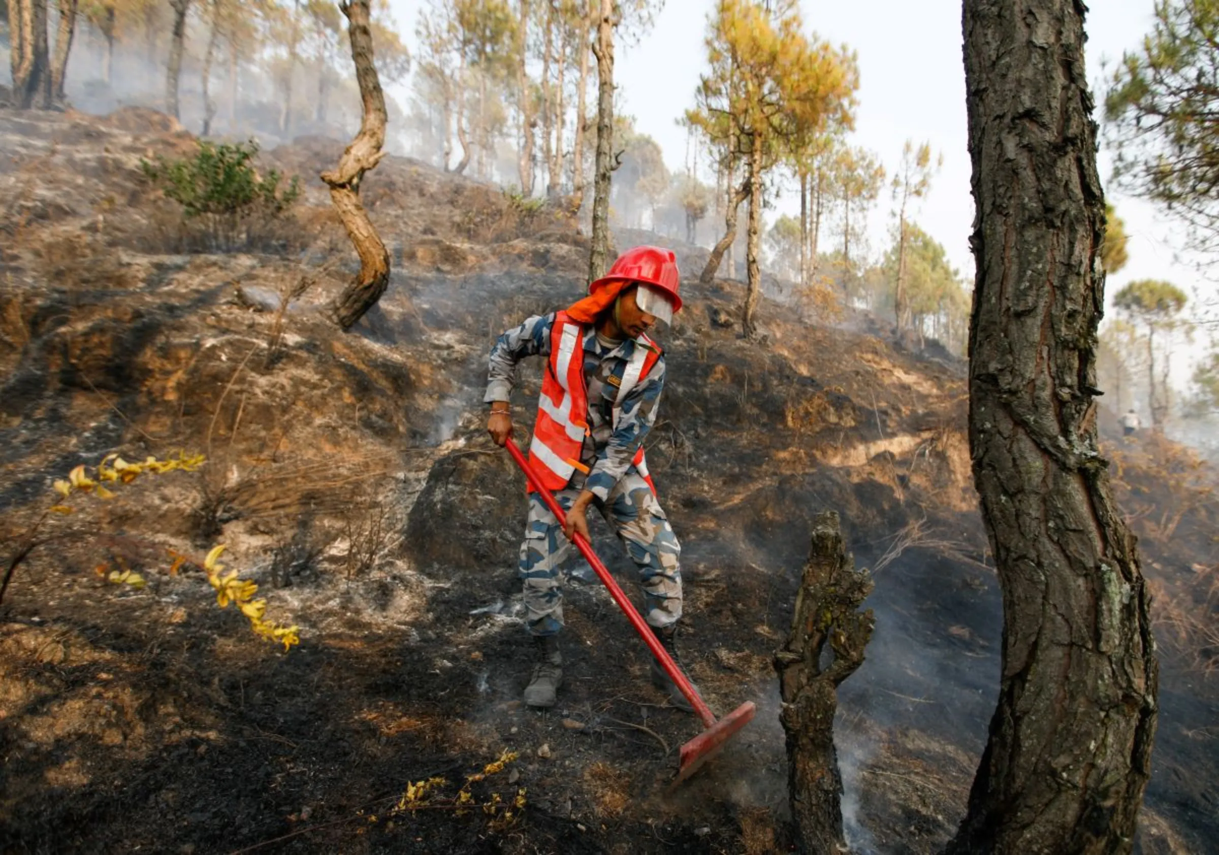 A member of the Armed Police Force works to control a forest fire at Shivapuri National Park overlooking Kathmandu, Nepal April 11, 2021. REUTERS/Navesh Chitrakar