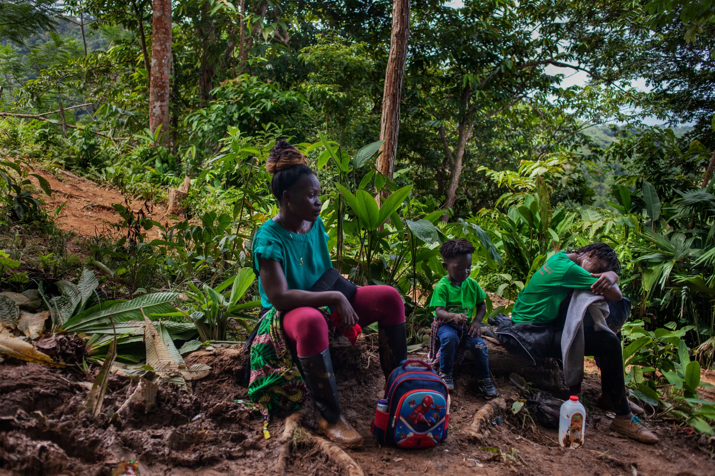 A migrant from Sierra Leone rests with her children during an exhausting trek through the Darién Gap, Colombia, July 27, 2022. Thomson Reuters Foundation/Fabio Cuttica