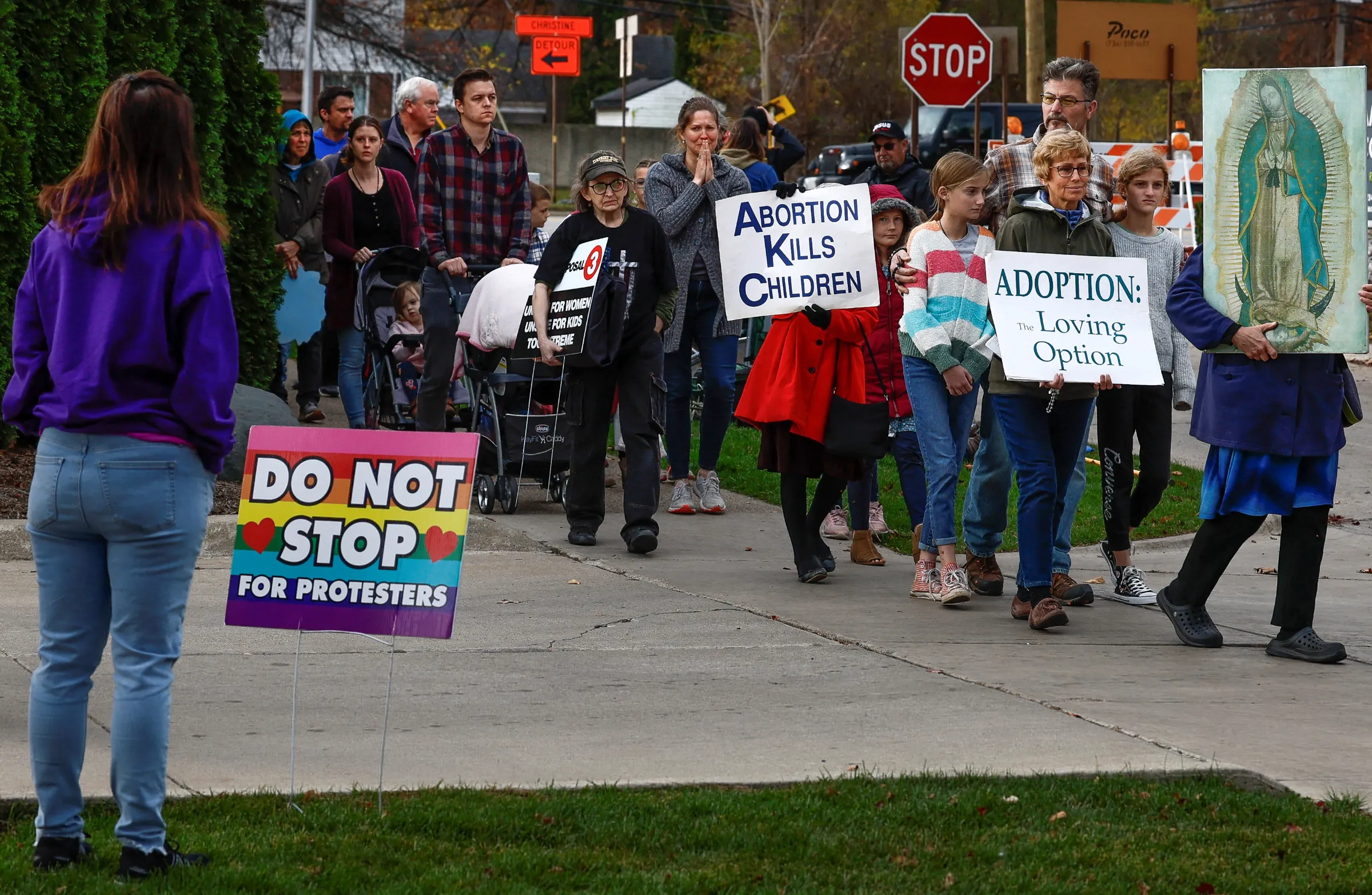 An abortion clinic escort watches Catholic groups pass Northland Family Planning during a prayer march to demonstrate against the ballot measure known as Proposal 3, which would codify the right to abortion, in Westland, Michigan, U.S., November 5, 2022