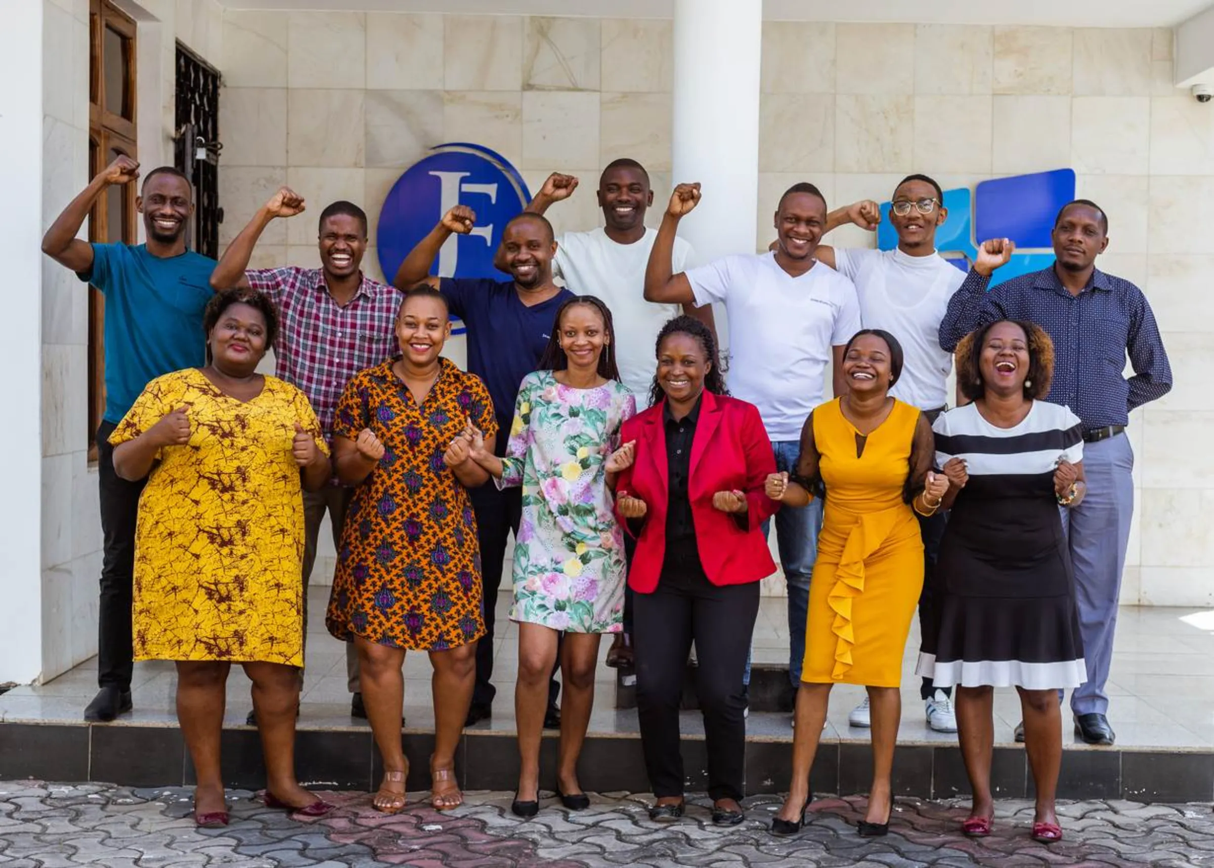 The JamiiForums team pose for a photo with their fists raised from their office in Dar es Salaam, Tanzania. May 27, 2022. Thomson Reuters Foundation/Yohana Haule