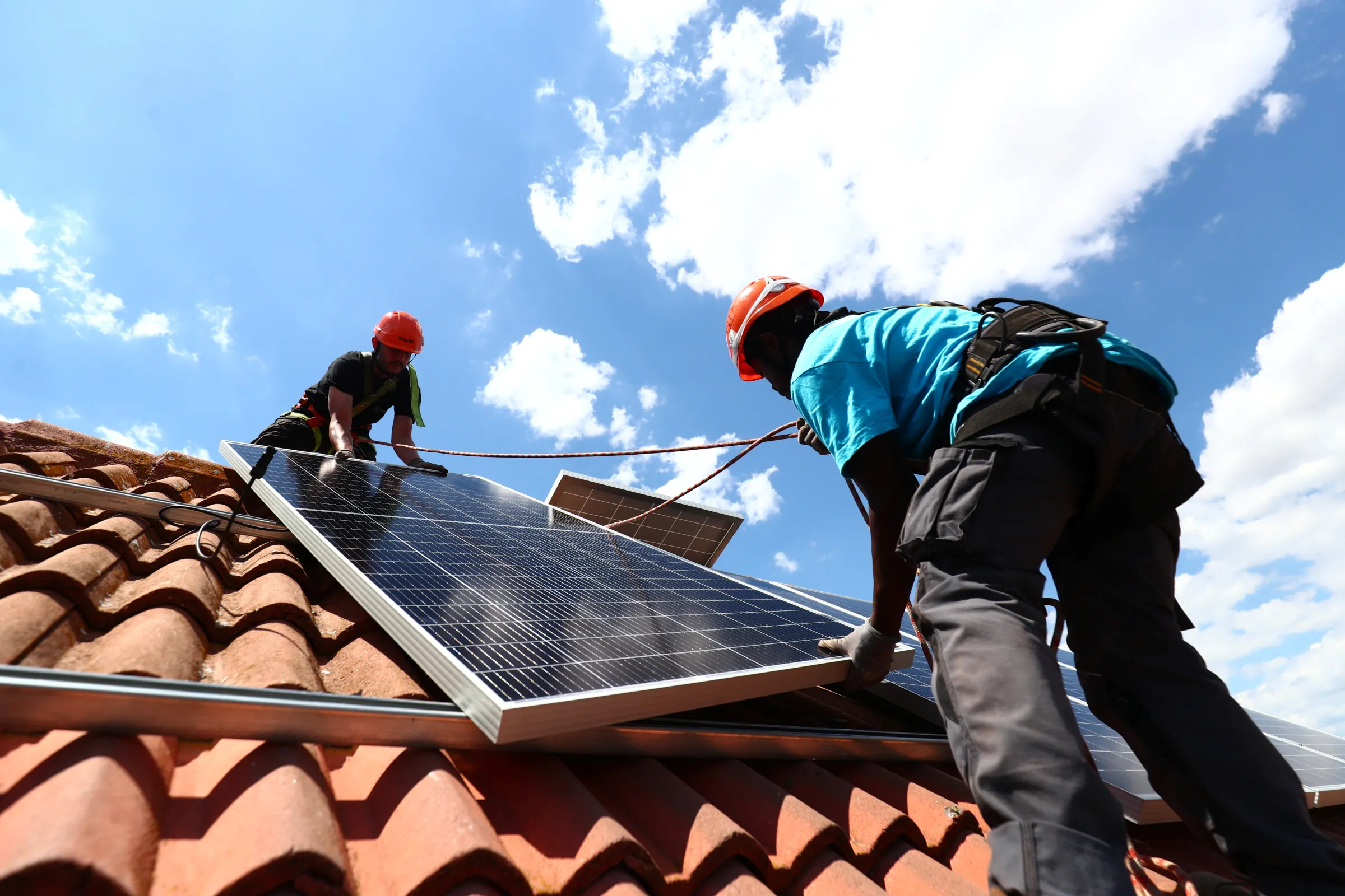 Installation workers set up solar panels on the roof of a home in Colmenar Viejo, Spain June 19, 2020. REUTERS/Sergio Perez