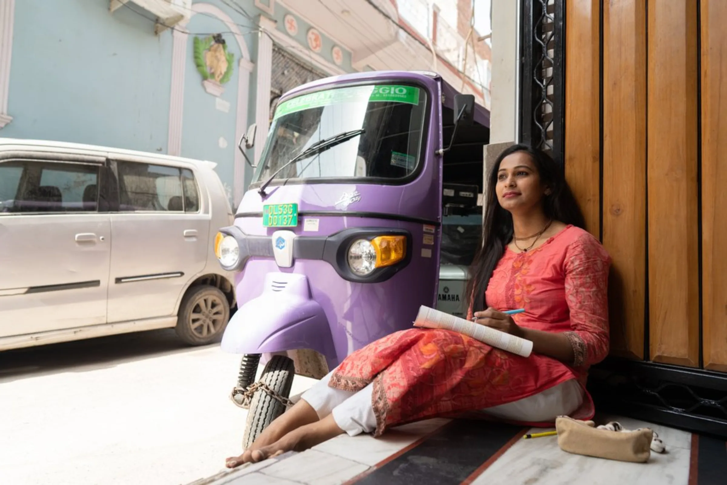 Dolly Maurya poses with her electric auto-rickshaw in Delhi, April 25, 2022