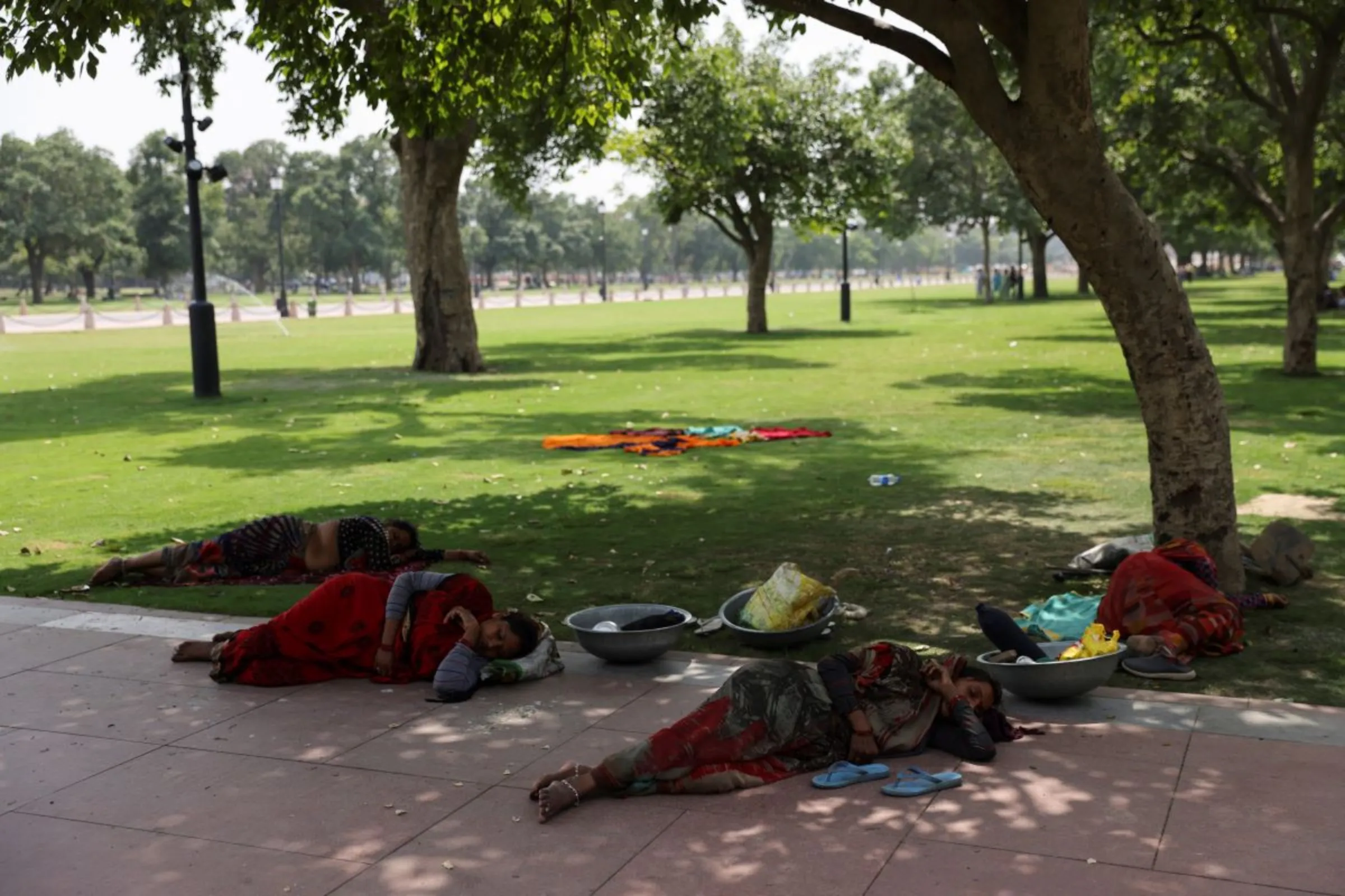 Women labourers take rest under a tree, on a hot summer day near India Gate, in New Delhi, India May 15, 2023. REUTERS/Anushree Fadnavis