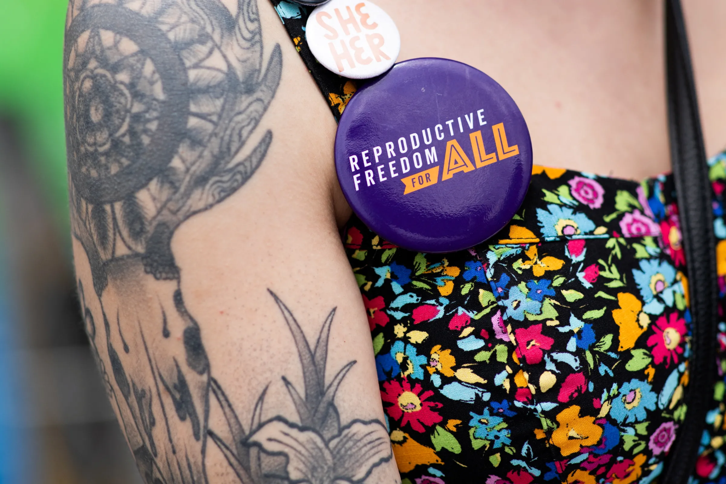 Volunteer Alex Cascio wears pins as she gathers signatures for a proposed abortion amendment