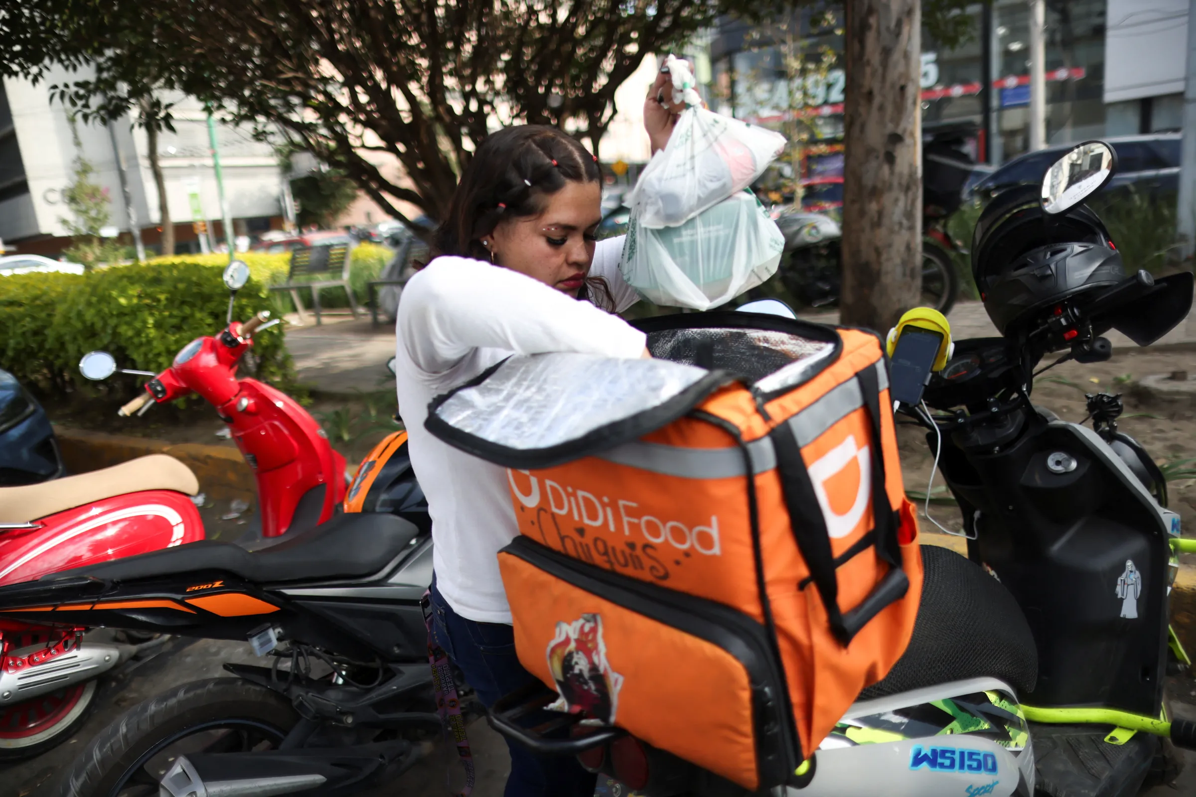 A delivery driver for Didi Food gets ready to deliver a food order as Mexico proposes a labor reform for drivers and delivery workers using applications like Uber, Didi and Rappi, officials said, in Mexico City, Mexico October 16, 2024. REUTERS/Gustavo Graf