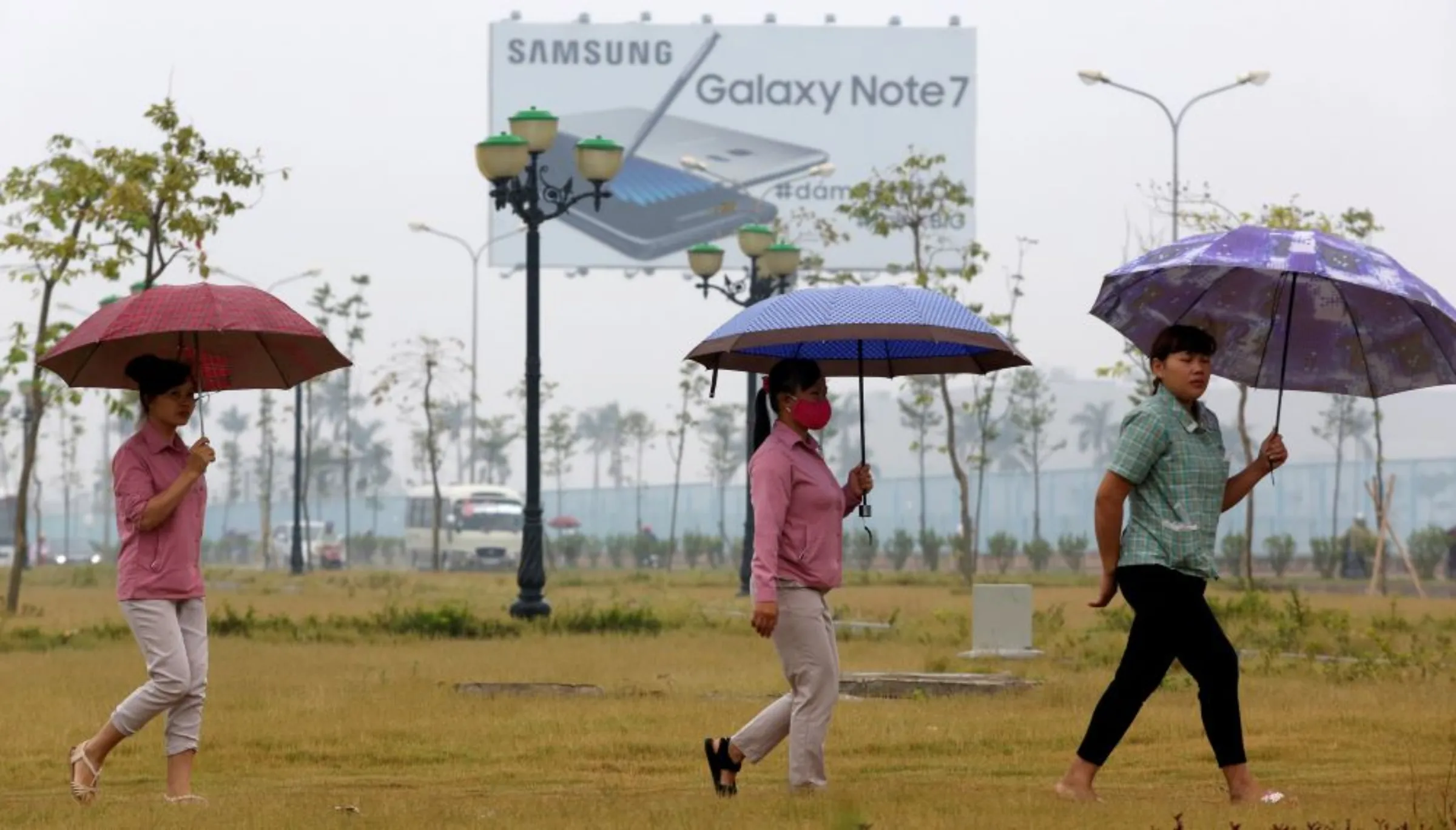 Employees pass a billboard advertisement for the Samsung Galaxy Note 7 on the way to work at the Samsung factory in Thai Nguyen province, north of Hanoi, Vietnam October 13, 2016. REUTERS/Kham