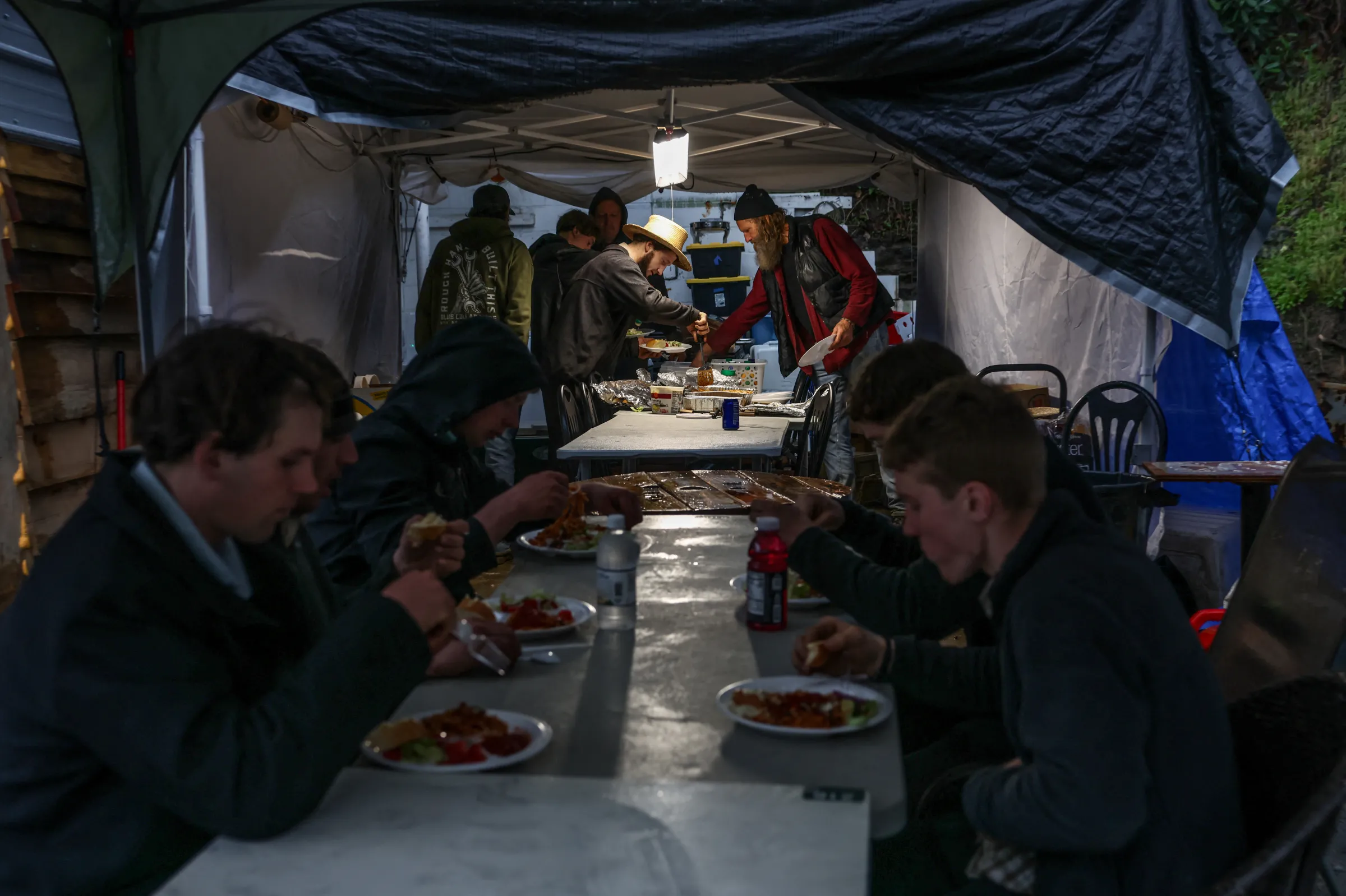 Amish volunteers eat dinner at the Bat Cave Disaster Relief Supply Hub after Hurricane Helene, in Bat Cave, North Carolina, U.S., April 7, 2025. REUTERS/Evelyn Hockstein