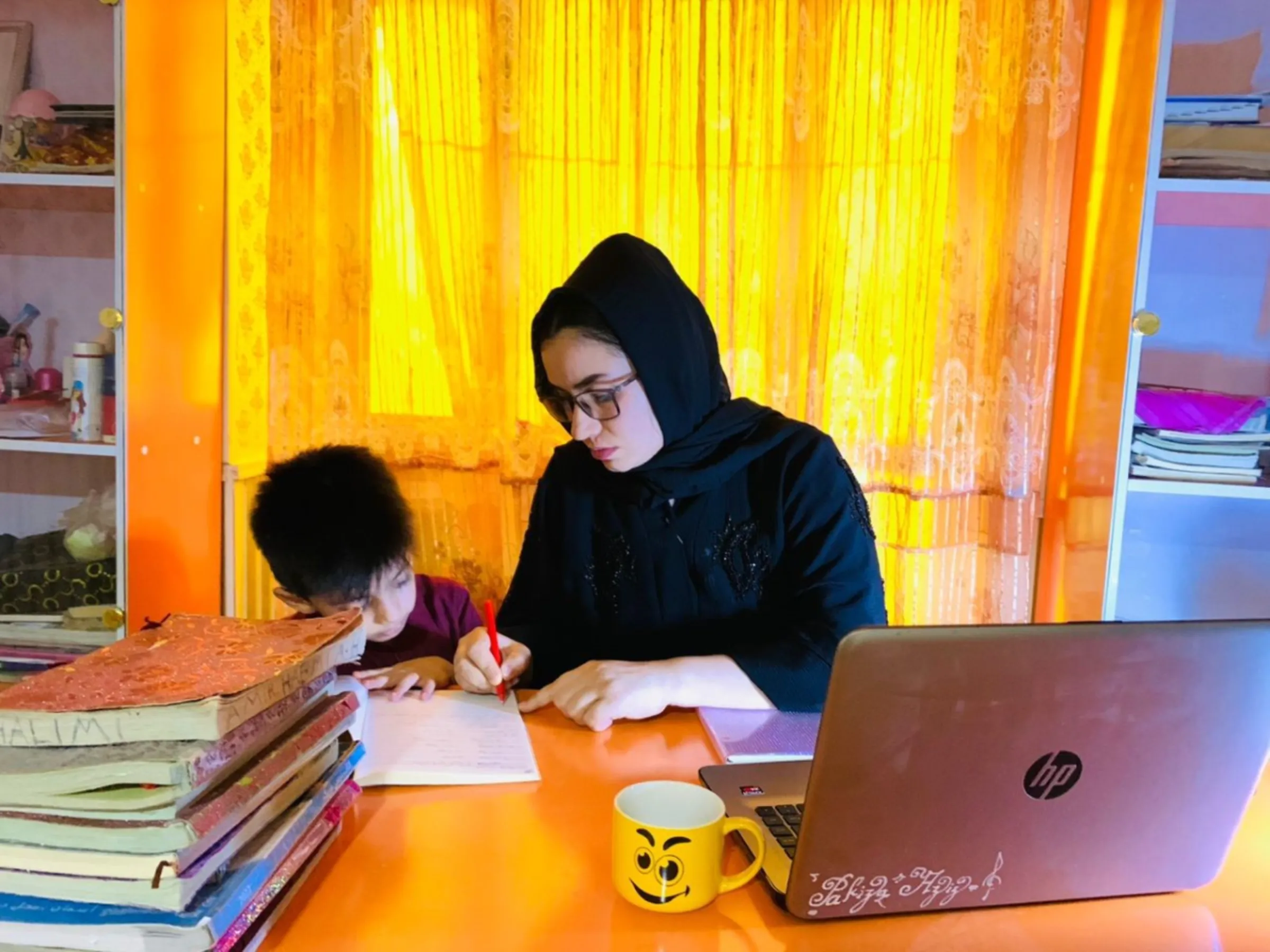Former aid worker Nilab Azizi tends to her son while preparing for a nursing course in Mazar-i-Sharif, Afghanistan. Photo taken August 2023