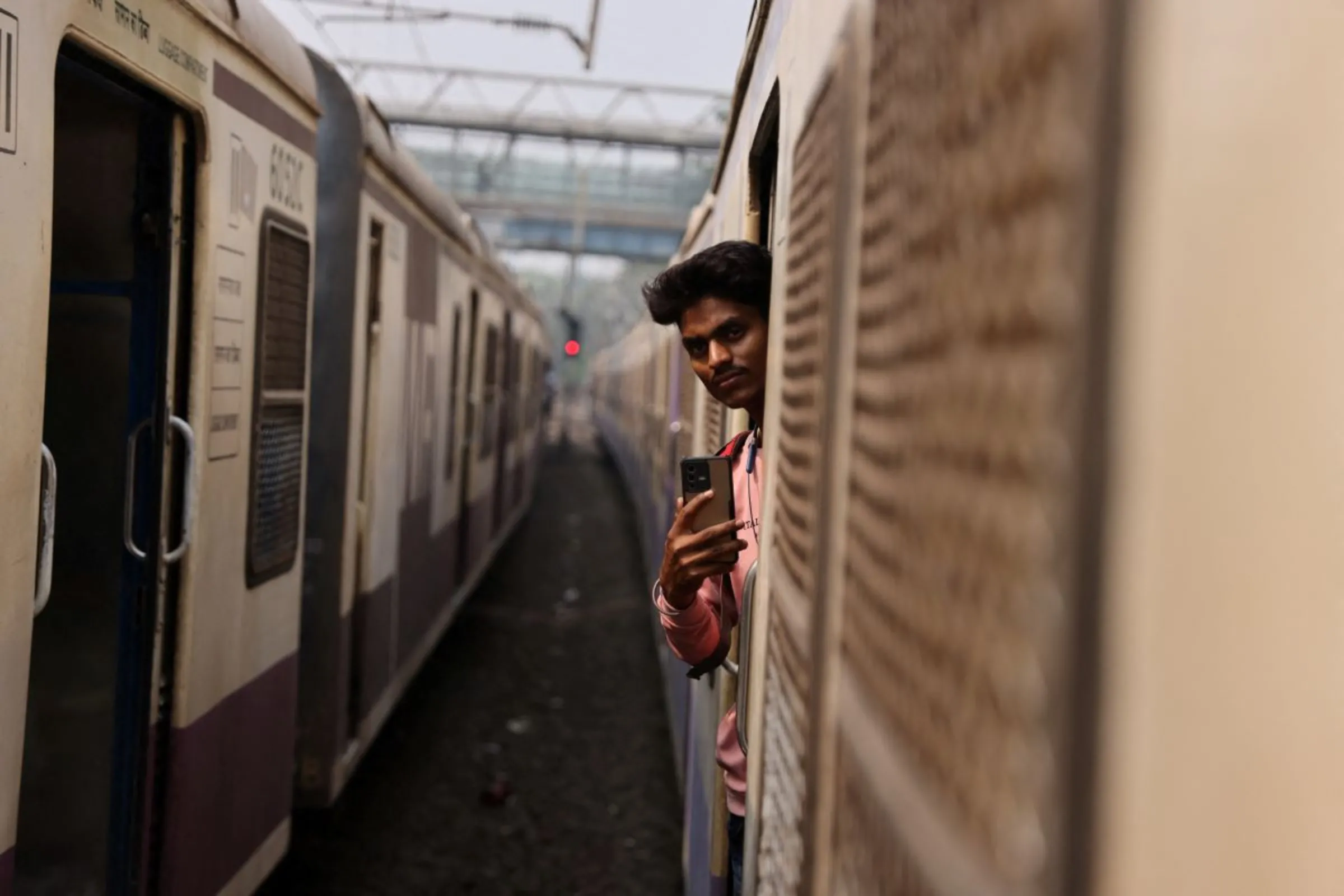 A man shoots a video on his mobile phone while on a local train in Mumbai, India, March 13, 2023