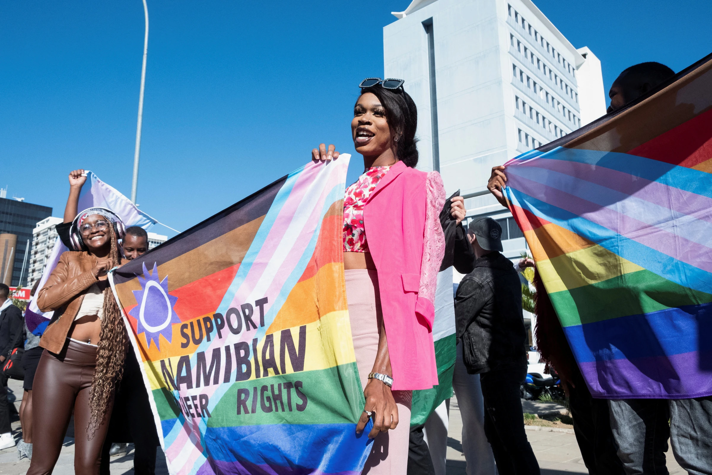 People hold banners in support of LGBTQ rights outside the high court which made a landmark ruling in favour of LGBTQ communities in Windhoek, Namibia, June 21, 2024 REUTERS/Opas Onucheyo