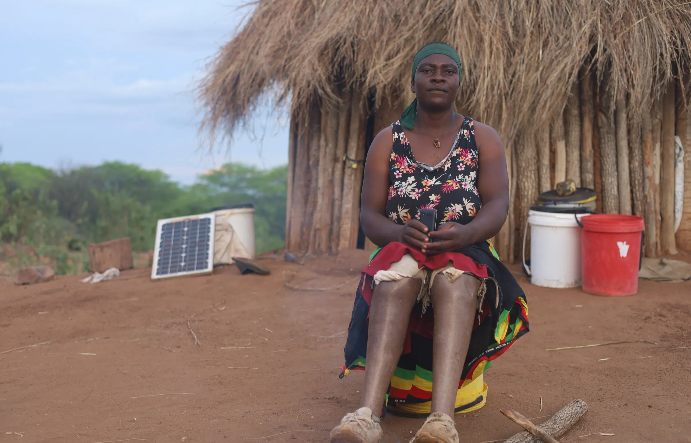 Agness Joe sits in front of her farmhouse on the Mozambican side of Zimbabwe's border, near Rushinga, Zimbabwe, Dec 7, 2025. Thomson Reuters Foundation/Farai Shawn Matiashe