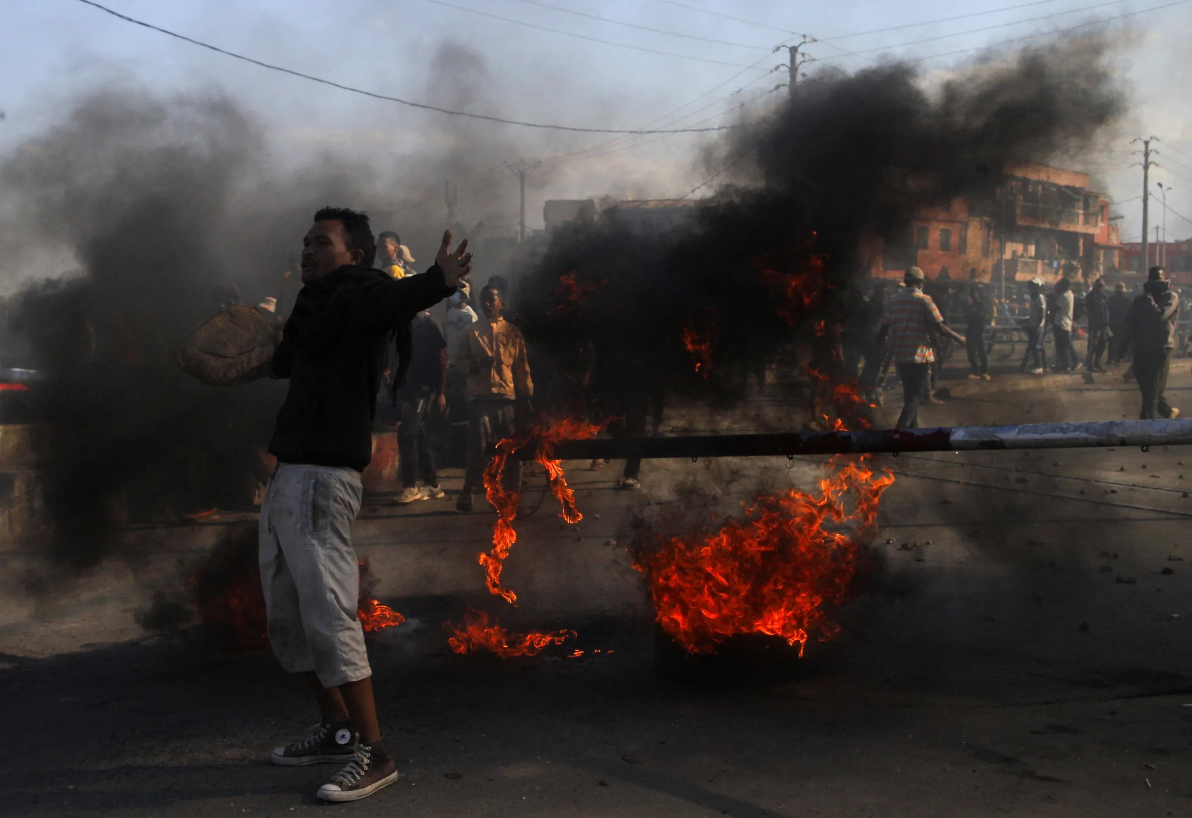 A protester reacts near a burning debris during a nationwide youth-led demonstration over frequent power outages and water shortages, in Antananarivo, Madagascar, October 7, 2025. REUTERS/Zo Andrianjafy