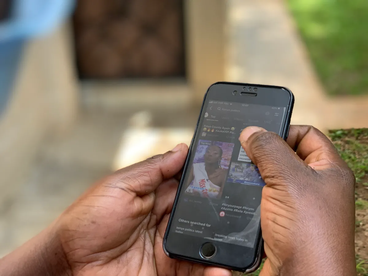 A Kenyan social media user checks her TikTok feed on her phone