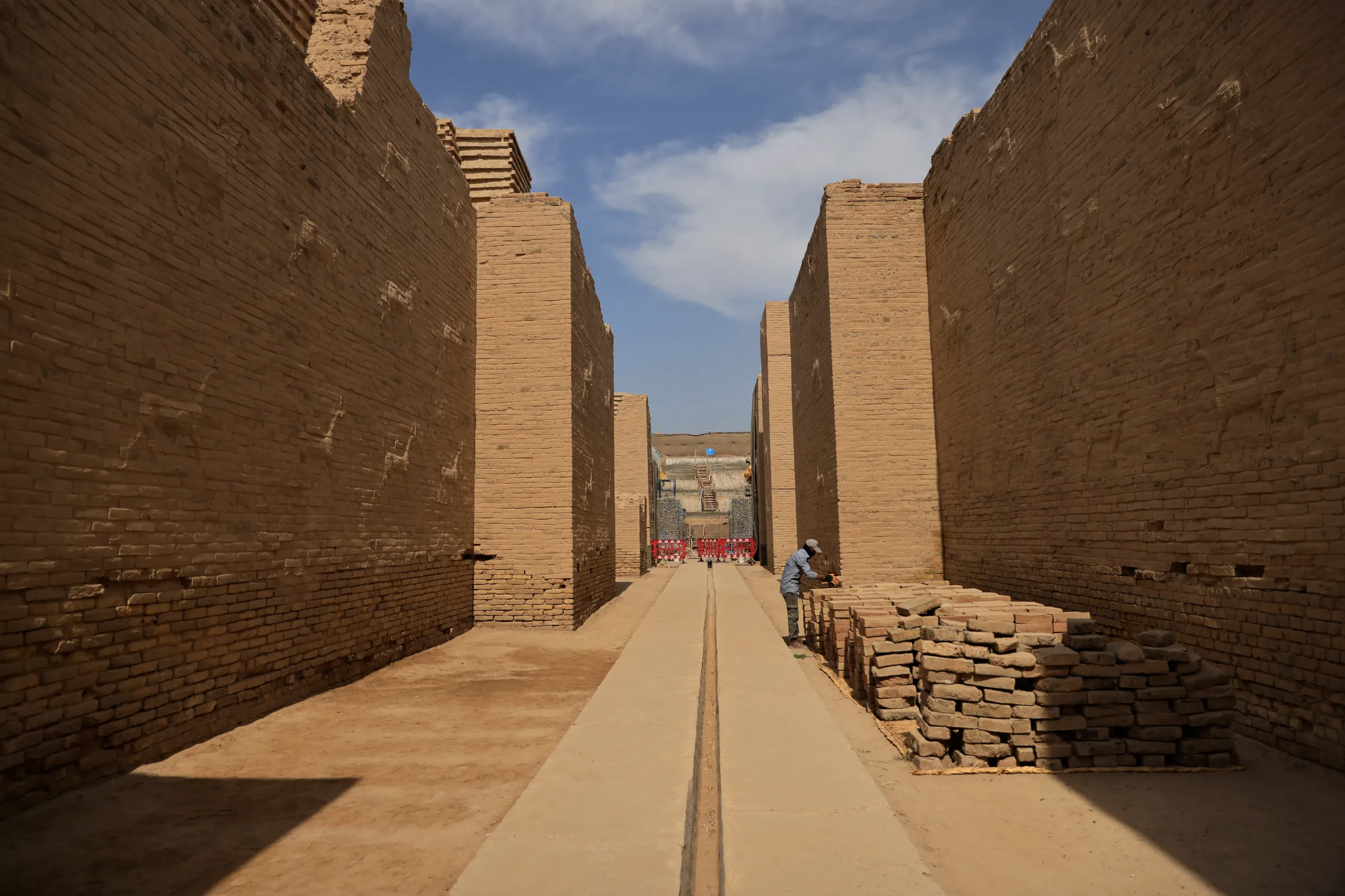 A worker from World Monument Fund sets out sun-crude bricks in the ancient city of Babylon, Iraq, October 13, 2022