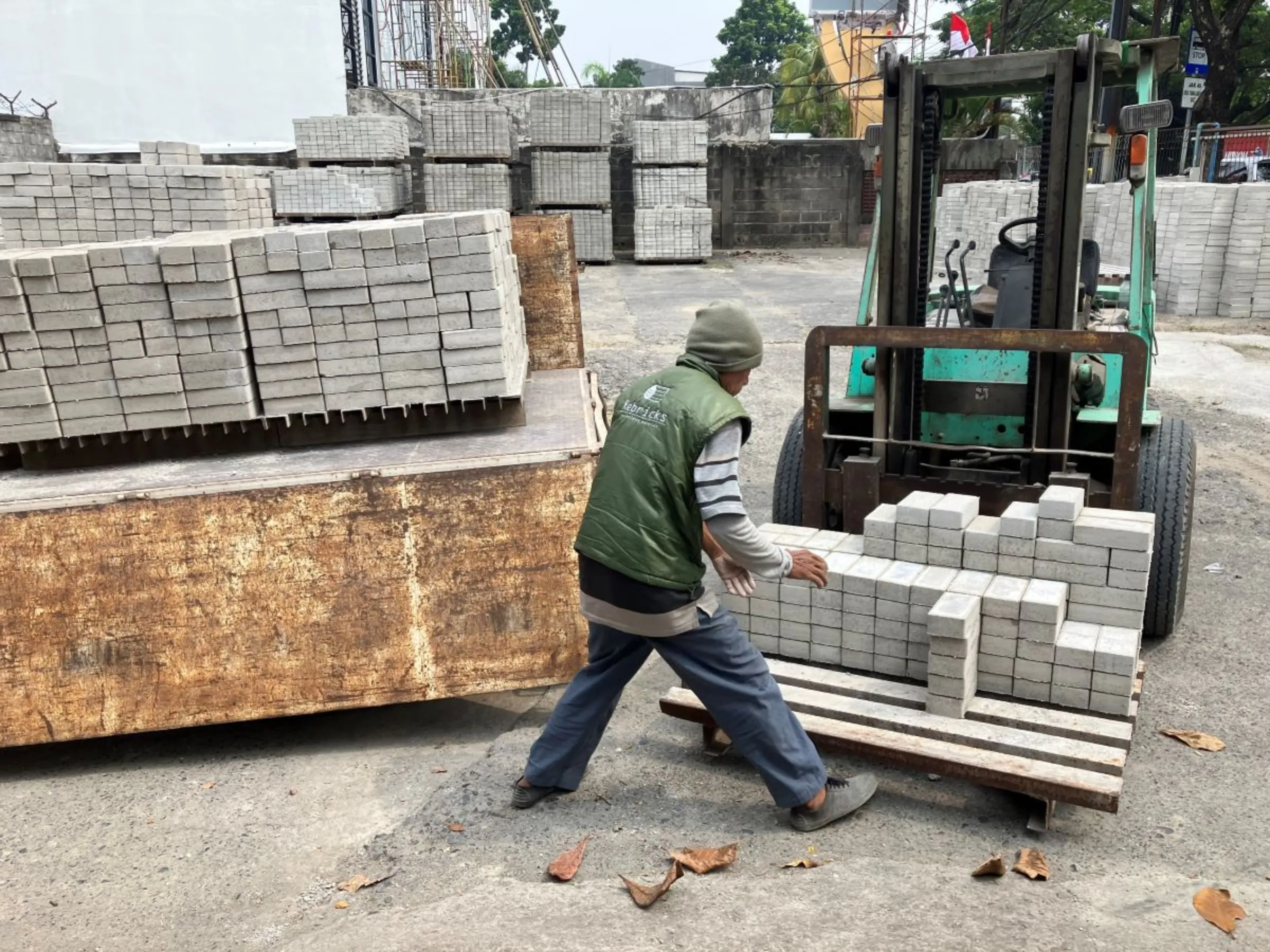 Rebricks workers at the building materials yard in Jakarta on August 12, 2023. Thomson Reuters Foundation/Michael Taylor