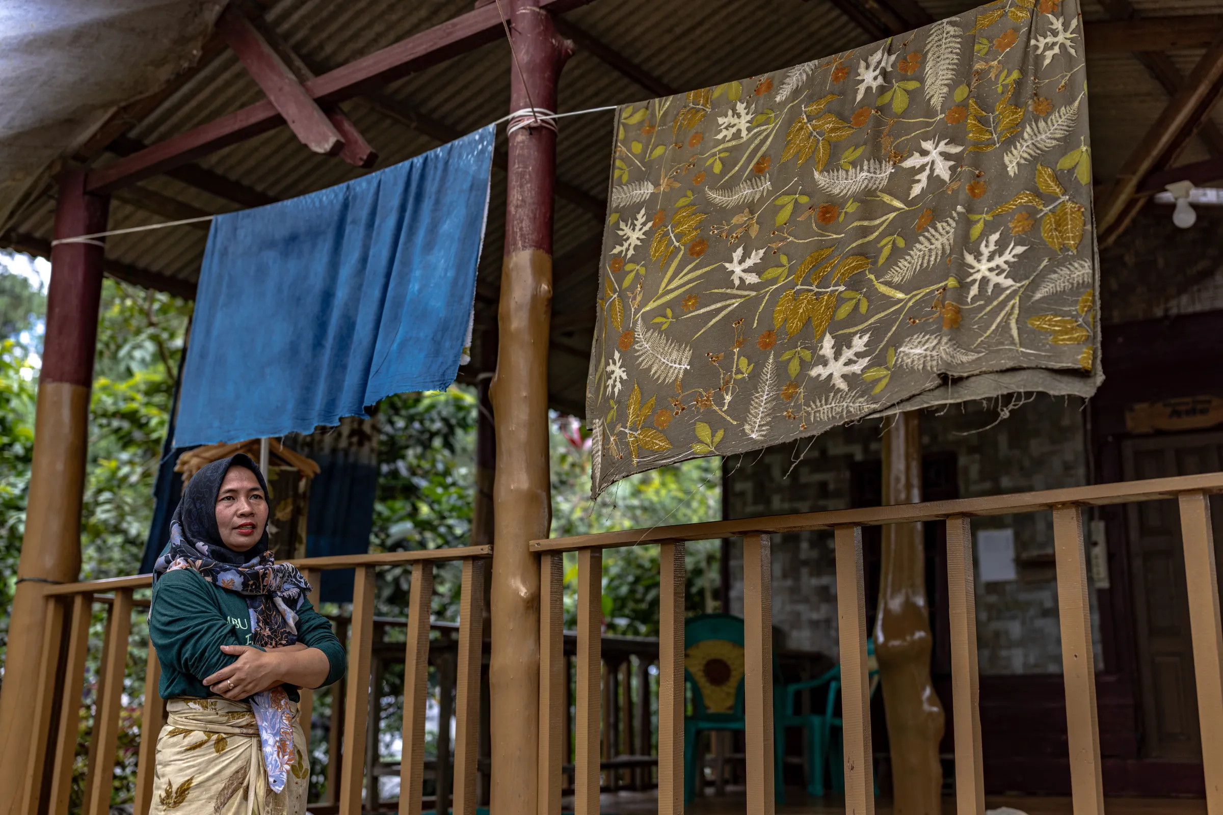 Wulan, a 40-year-old member of the Ambu Halimun community—a group of women living in Citalahab Sentral within the Mount Halimun Salak National Park—poses with her ecoprint products in West Java, Indonesia, July 16, 2025. Thomson Reuters Foundation/Yudha Baskoro