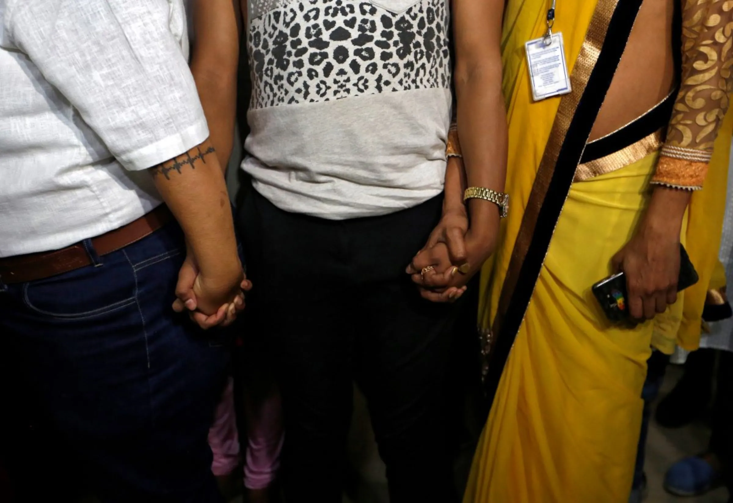 Supporters of the lesbian, gay, bisexual and transgender (LGBT) community hold hands as they wait for the Supreme Court's verdict on decriminalizing gay sex, at an NGO in Mumbai, India, September 6, 2018. REUTERS/Francis Mascarenhas