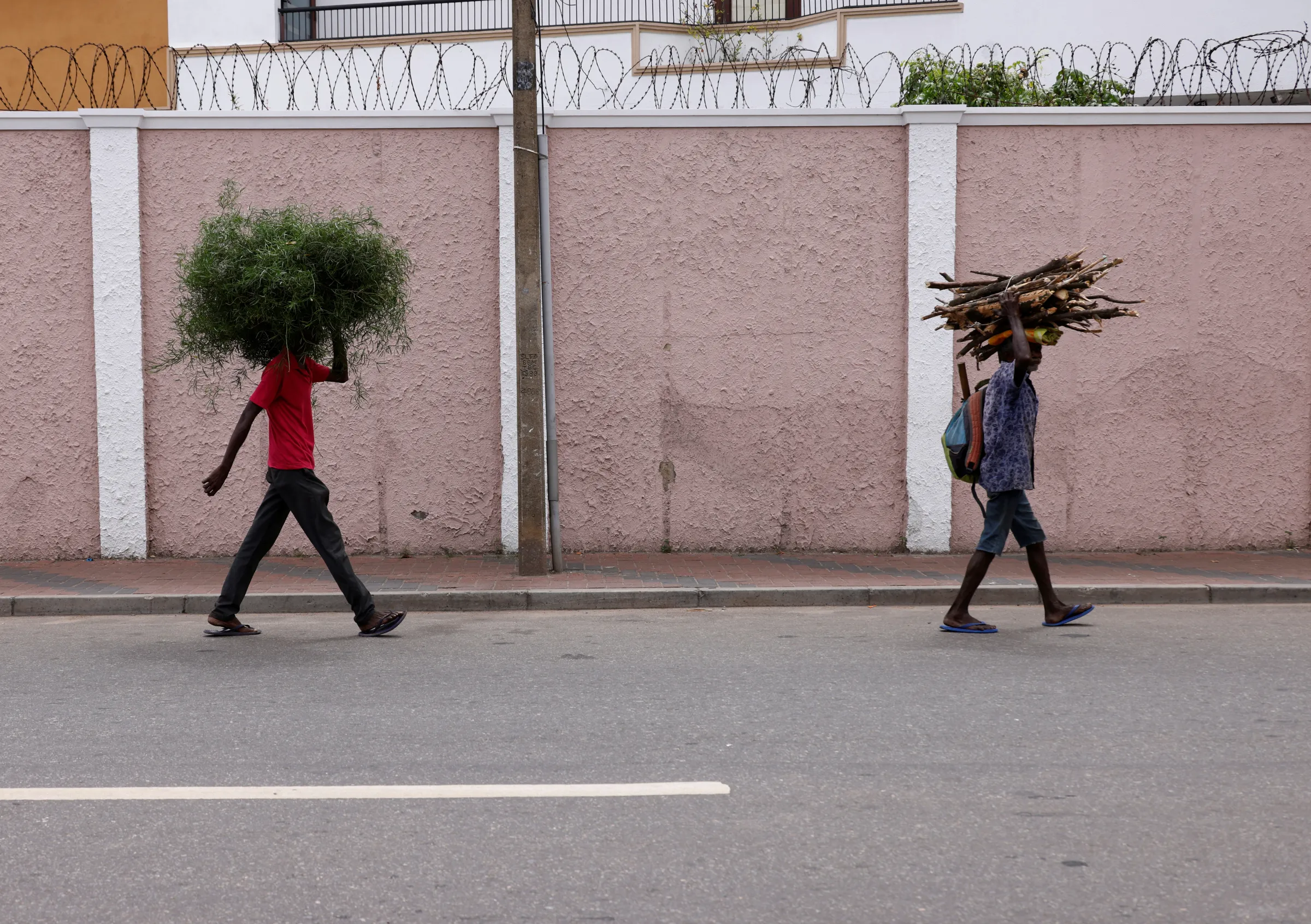 Men carry firewoods to sell them in a market in the fuel shortage