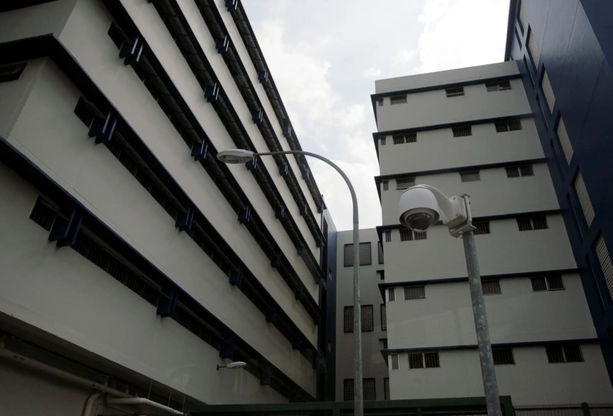 A view taken through a vehicle window shows a surveillance camera in front of cell blocks inside Changi Prison in Singapore May 26, 2009