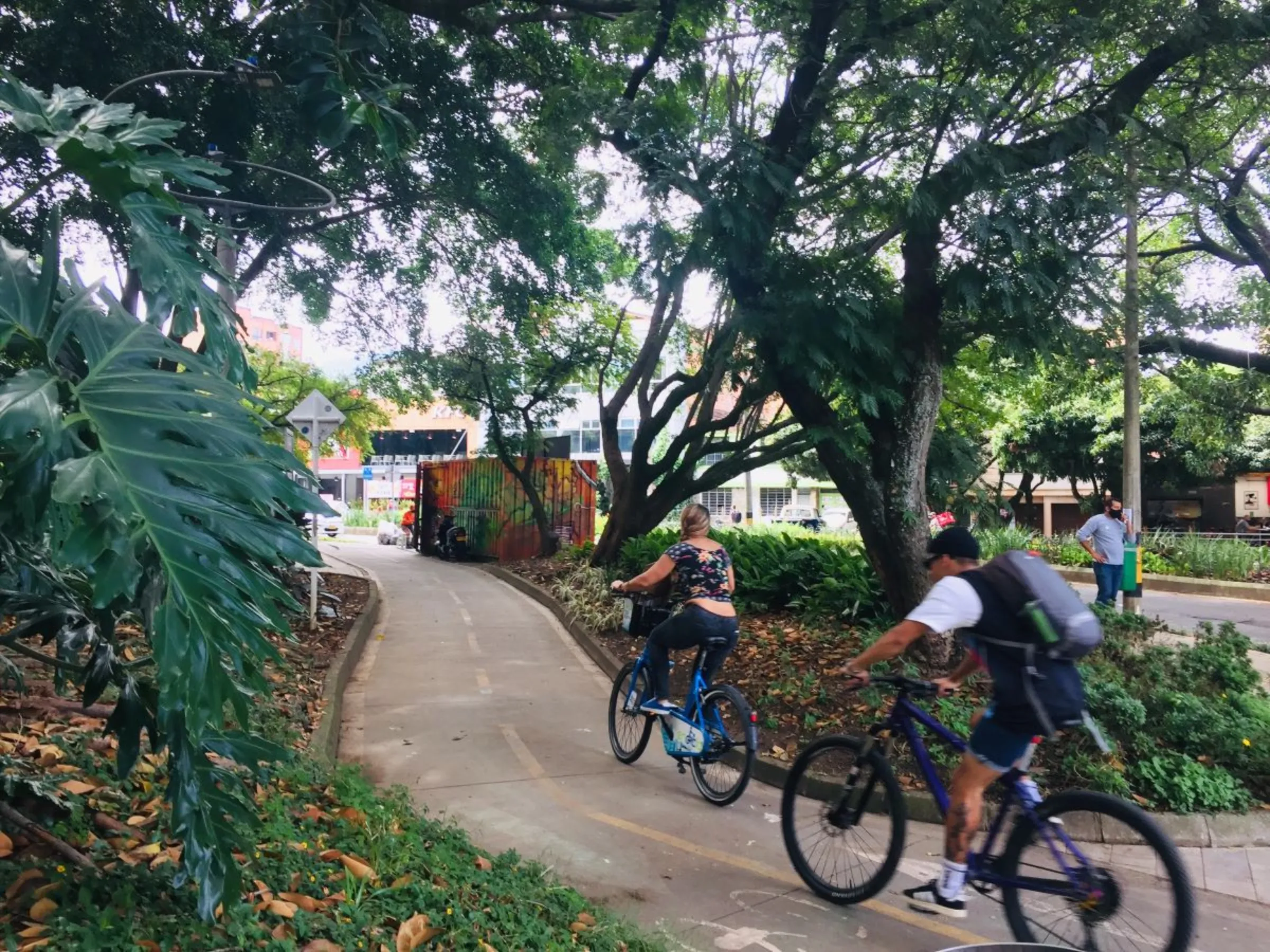 Cyclists along a tree-shaded pathway in Medellin, Colombia, July 16, 2021. Thomson Reuters Foundation/ Anastasia Moloney