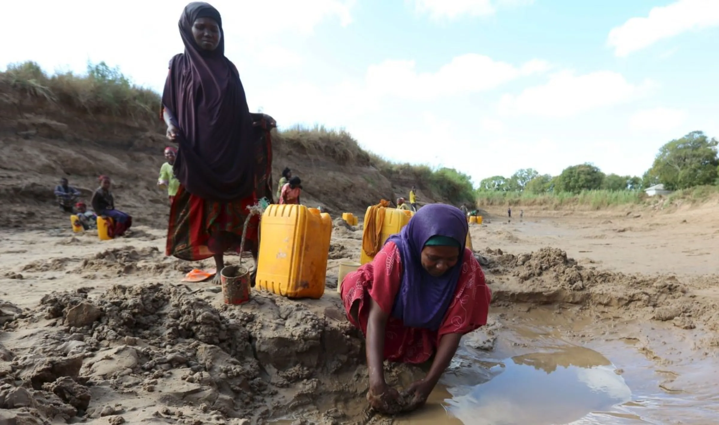 People collect water from shallow wells dug along the Shabelle River bed, which is dry due to drought in Somalia's Shabelle region, March 19, 2016