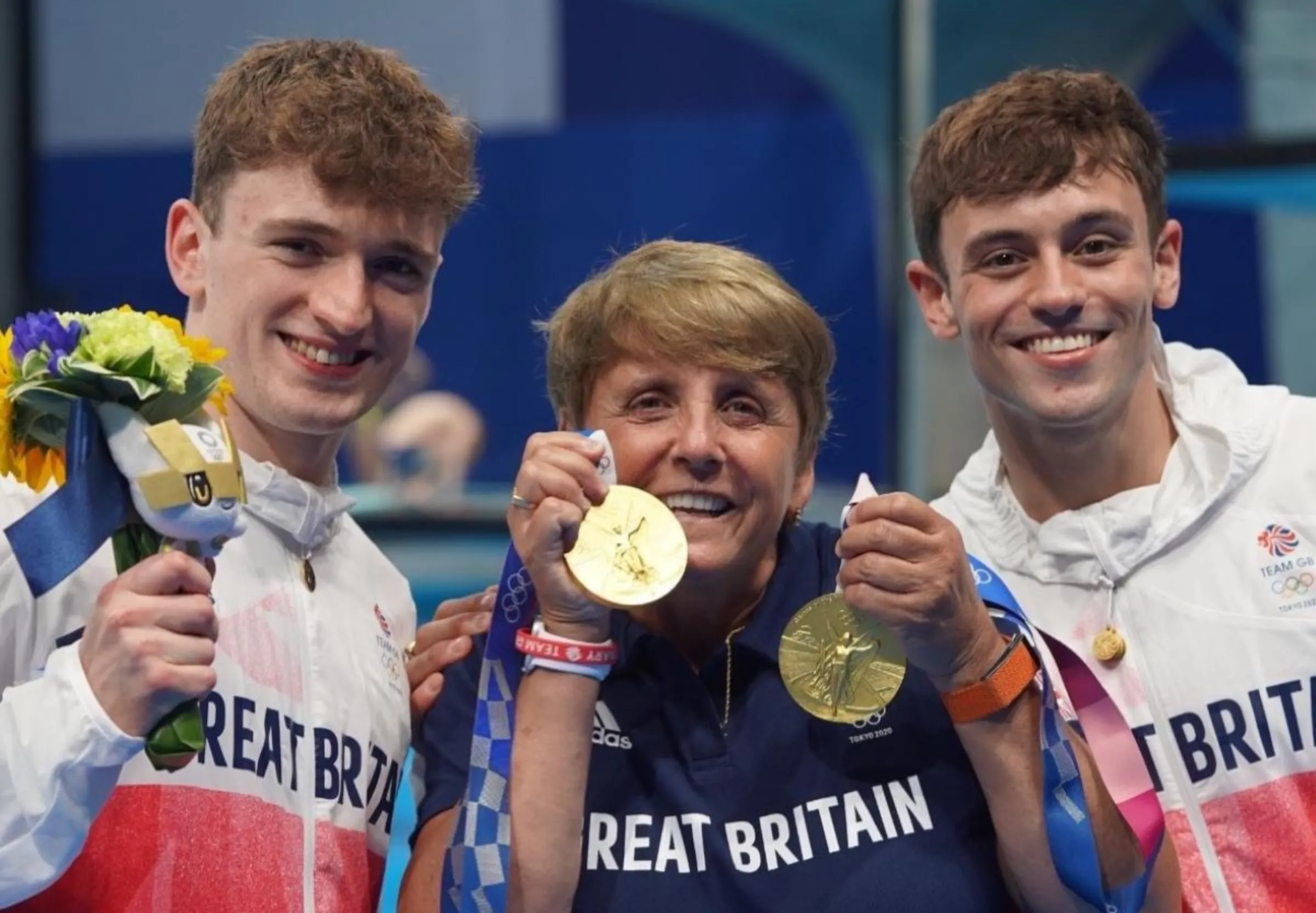 British diving champions Tom Daley and Matthew Lee with their coach Jane Figueirdo show off their gold medals at the Tokyo Games in 2021.  Thomson Reuters Foundation/Handout via Female Coaching Network