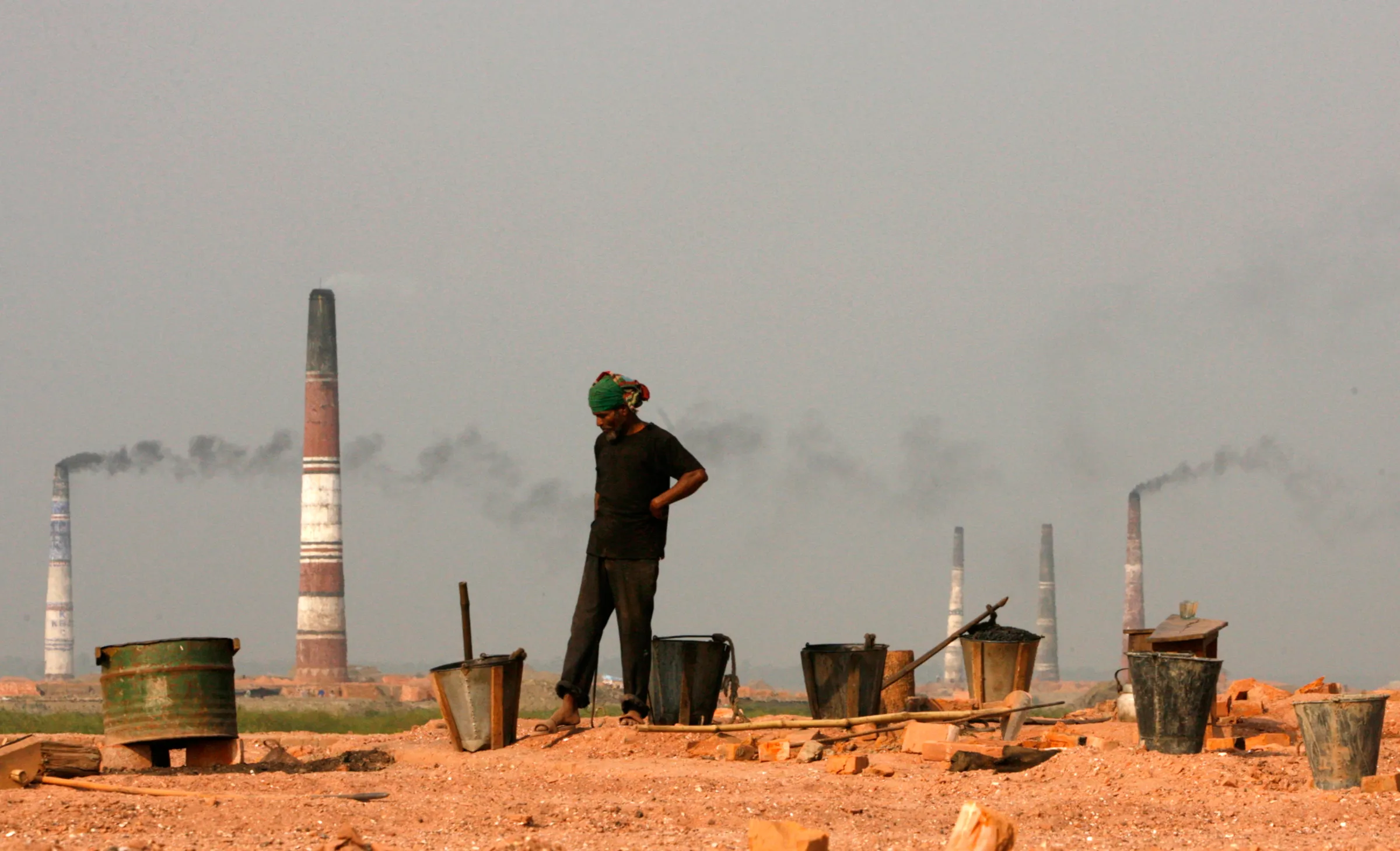 A labourer waits to load coals into the oven of a brickyard