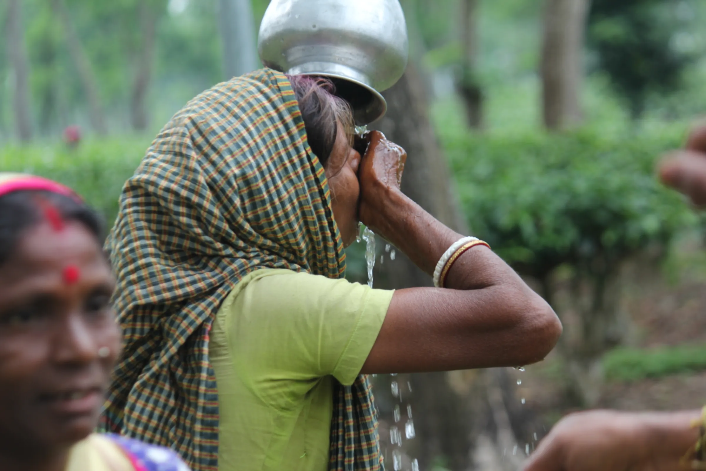 Mini Hazra, a tea picker, drinks water at Jangalbari tea estate in Sreemangal, in northeastern Bangladesh, May 23, 2023