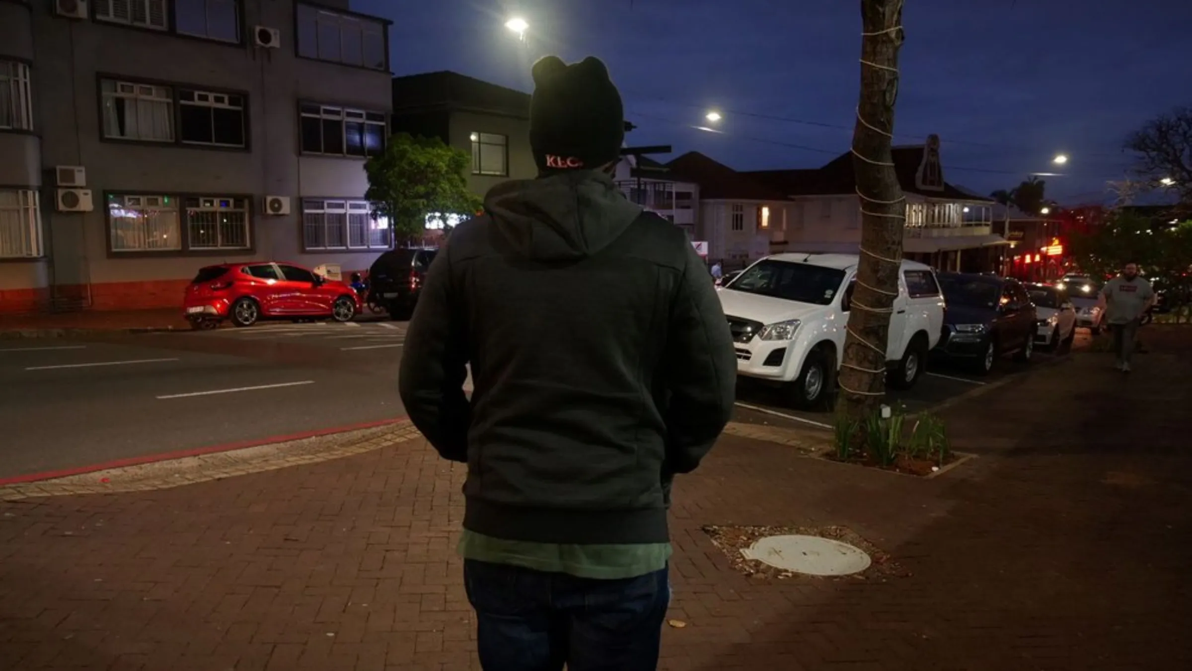 Uber food courier, Michael, stands in the street where his cousin was killed while working for the same company in Durban, South Africa as a car drives past. October 27, 2021