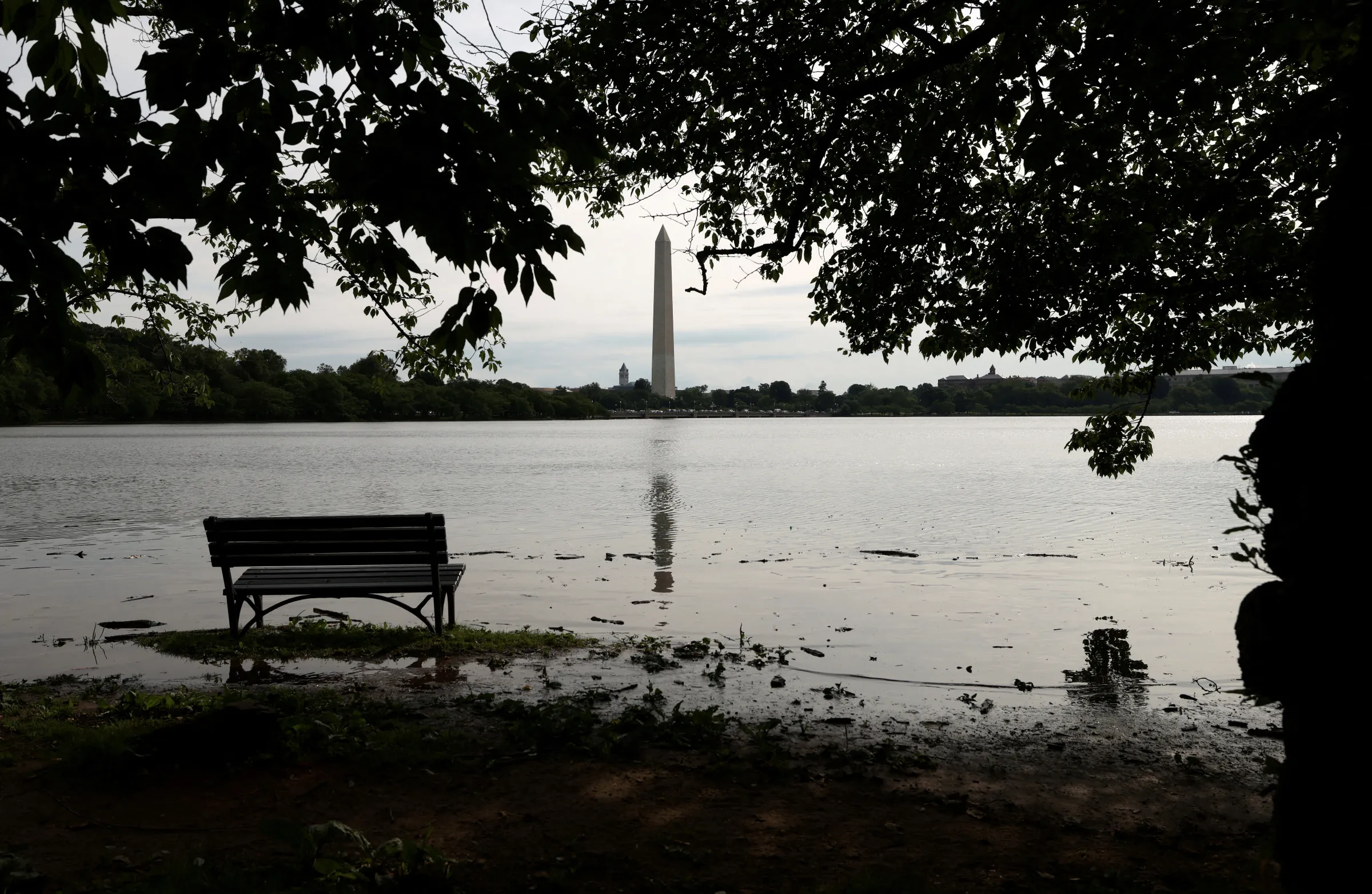 Water surrounds a bench as a project to rebuild the seawalls, damaged by age and rising sea levels, continues along the Tidal Basin in Washington, D.C., U.S., June 10, 2025. REUTERS/Kevin Lamarque